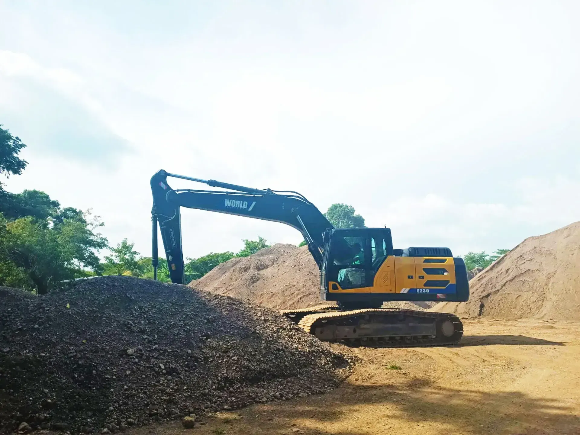 Una gran excavadora está sentada encima de un montón de tierra.