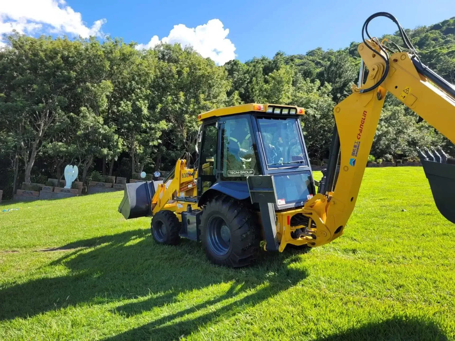 Un tractor amarillo está estacionado en un campo de hierba.