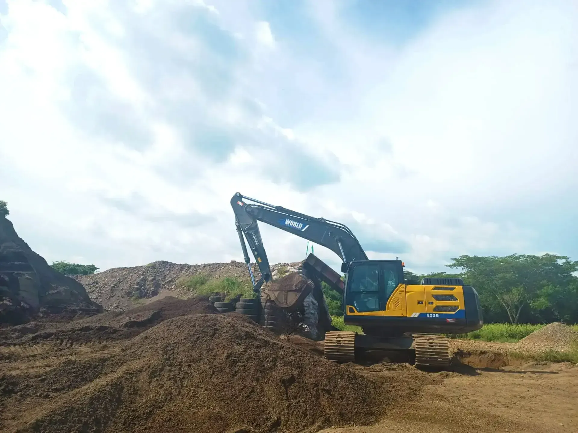 Una excavadora amarilla y negra está trabajando en un montón de tierra