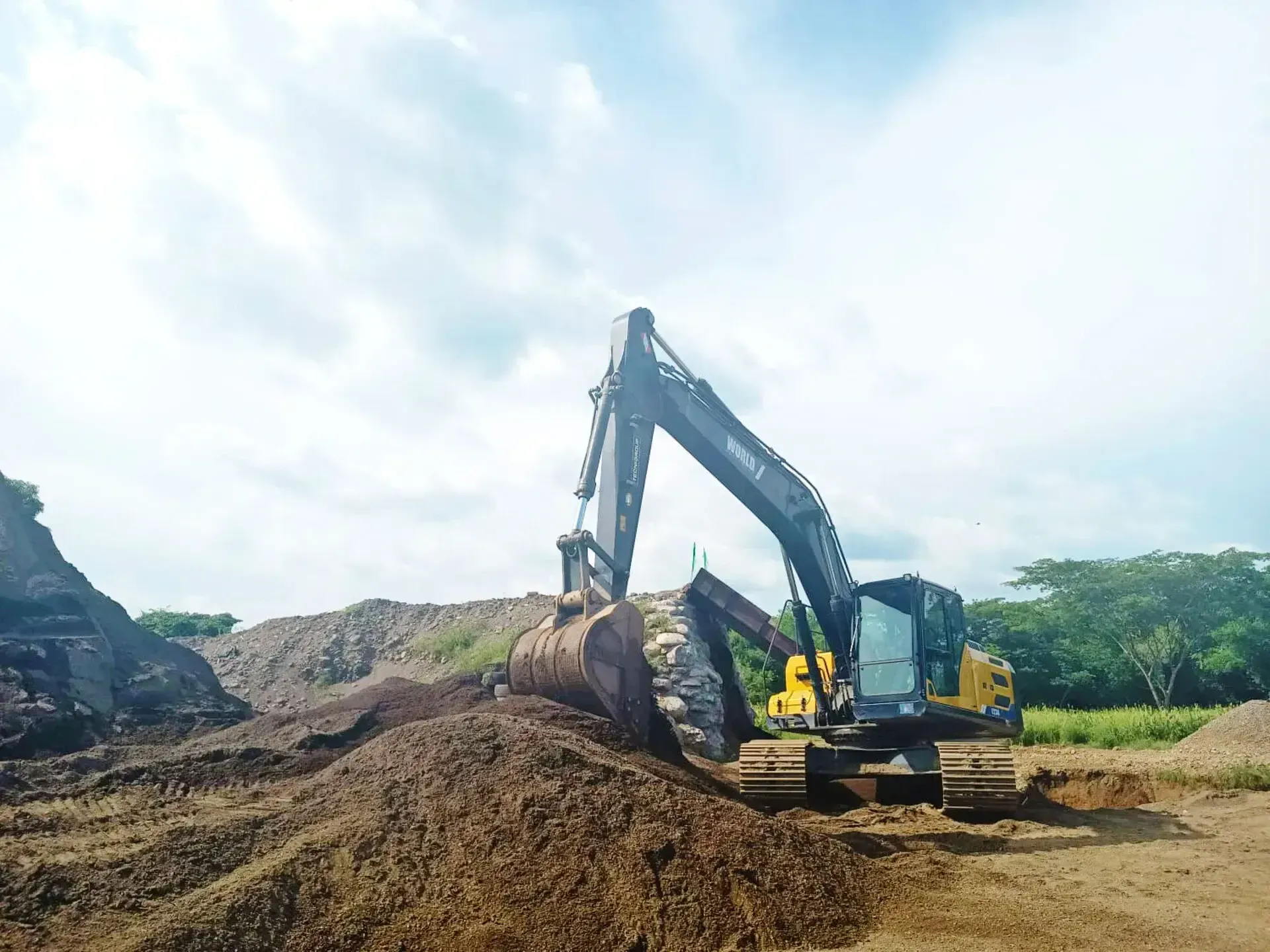 Una gran excavadora está moviendo tierra en un campo.
