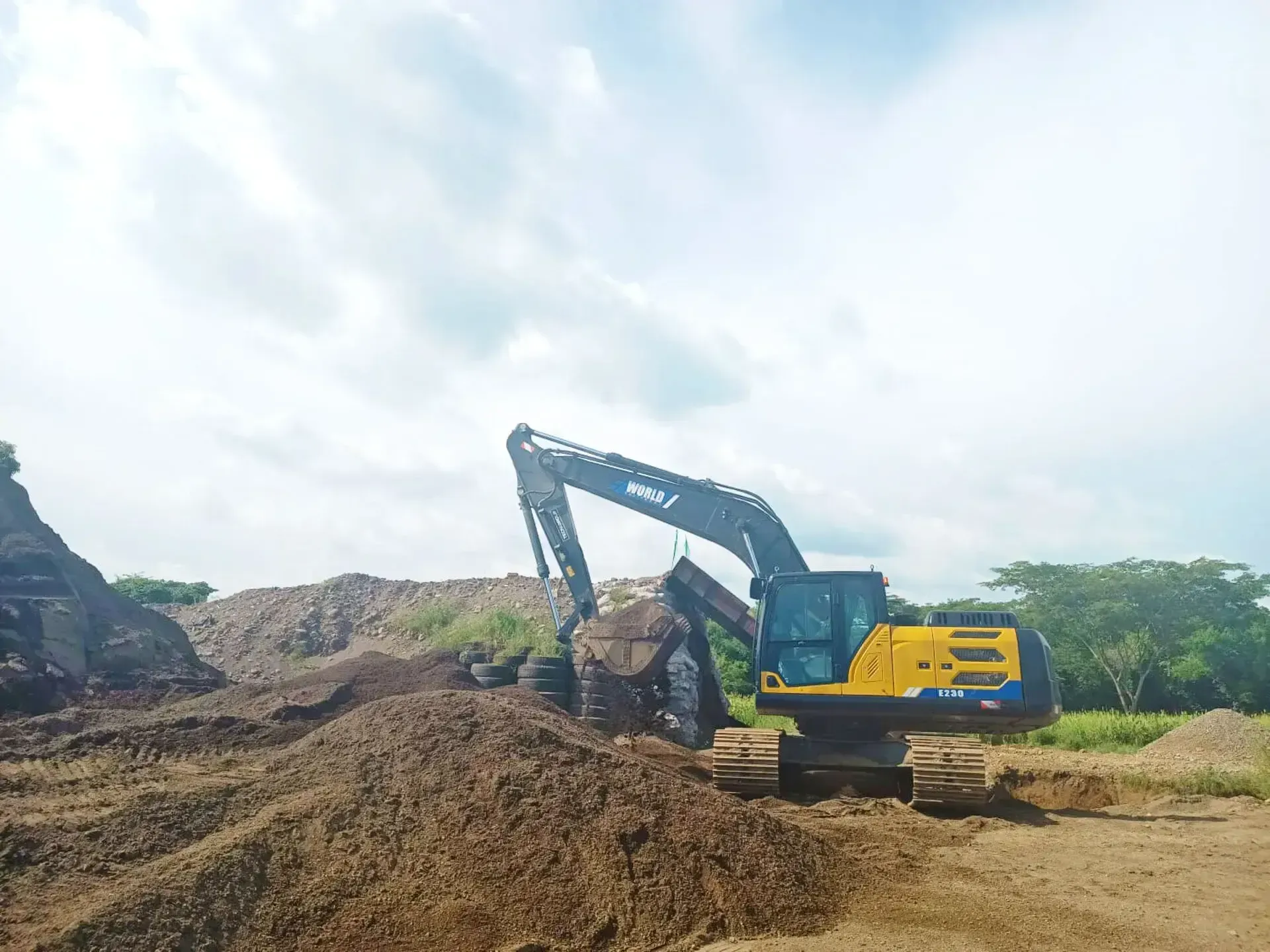 Una excavadora amarilla y negra está cavando en un montón de tierra.