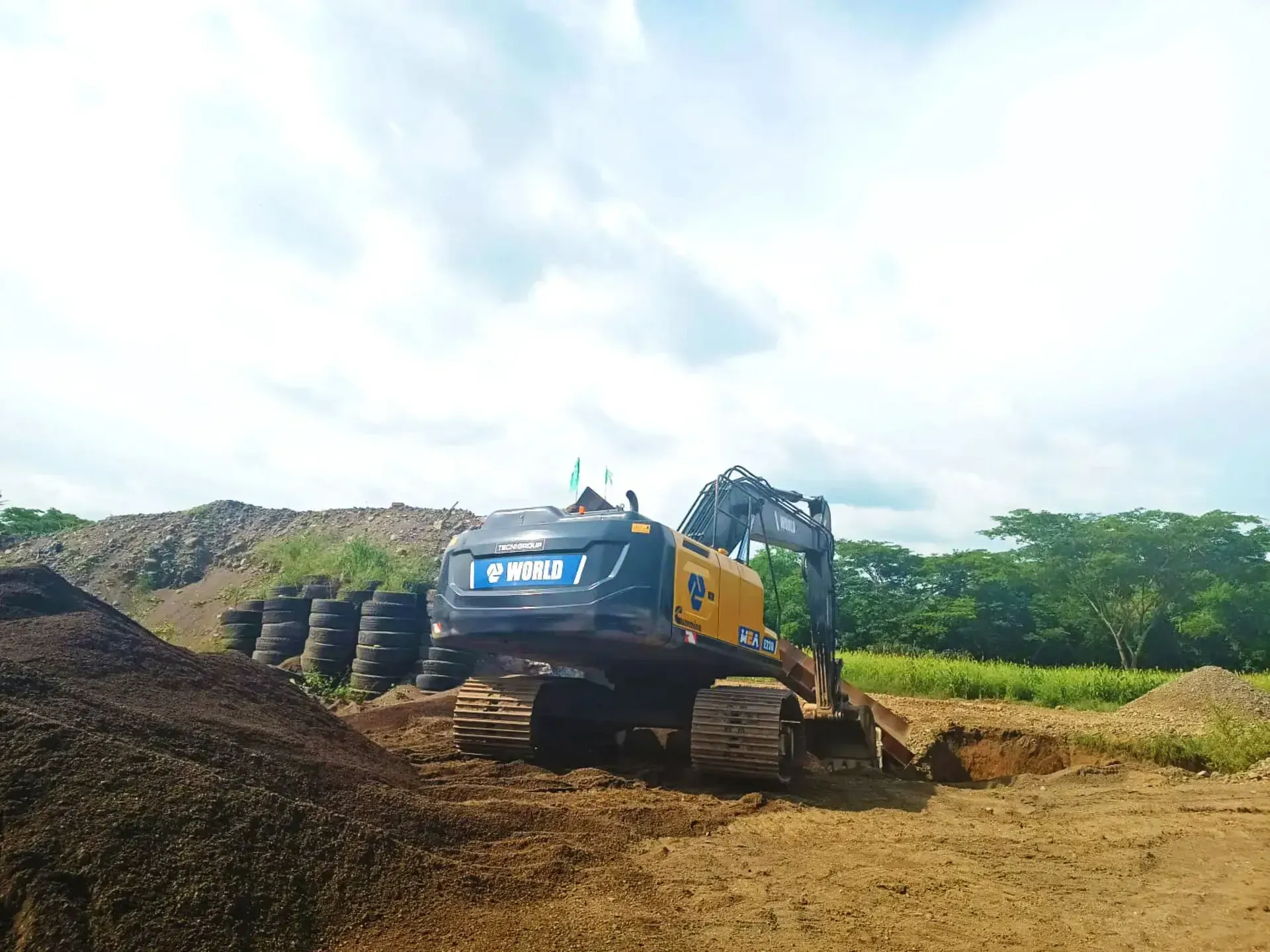 Una gran excavadora está cavando un hoyo en un campo de tierra.