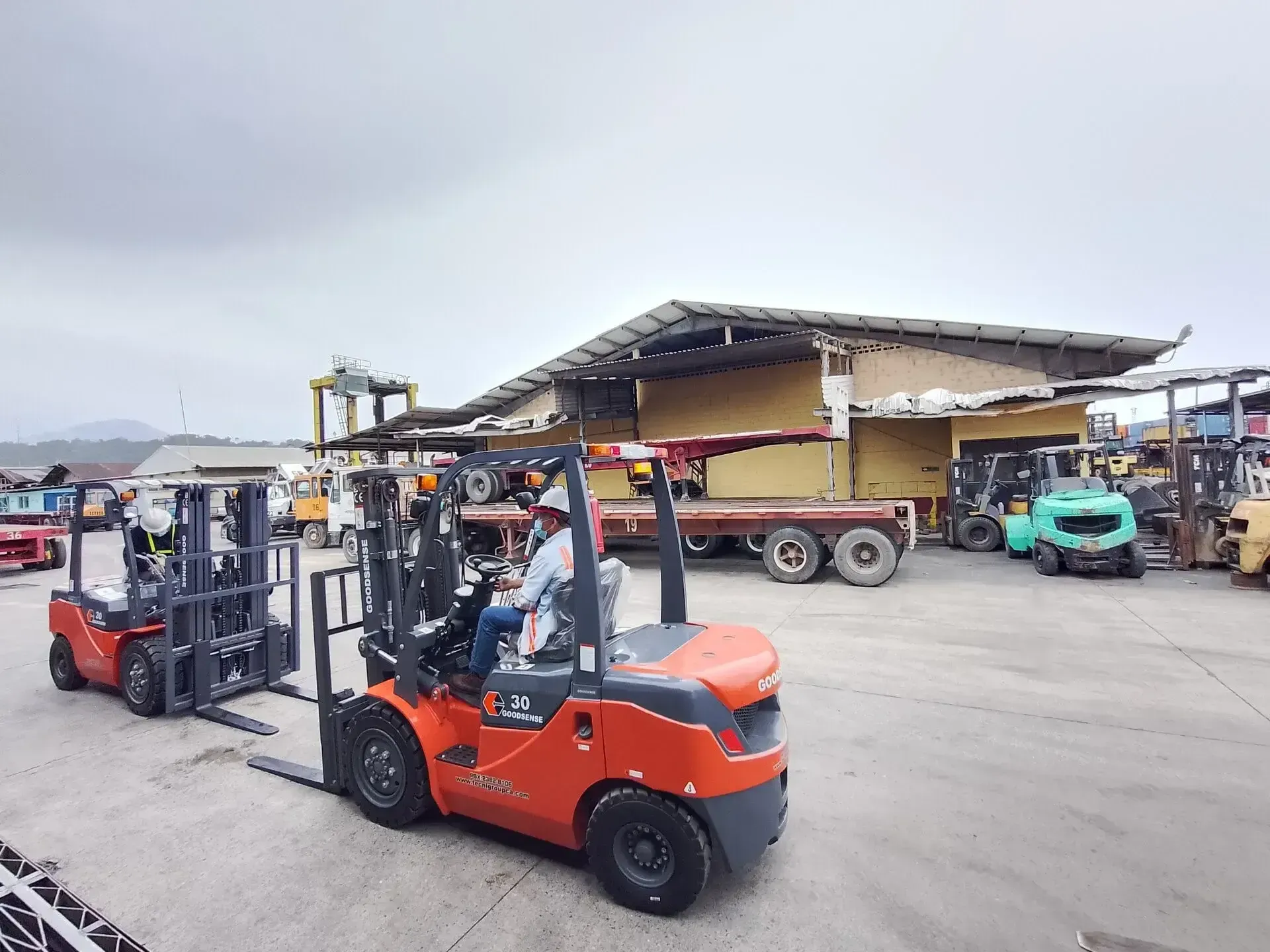 Un hombre conduce un montacargas en un estacionamiento.