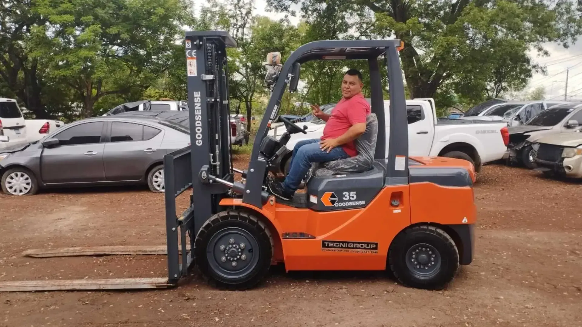 Un hombre conduce un montacargas en un estacionamiento.