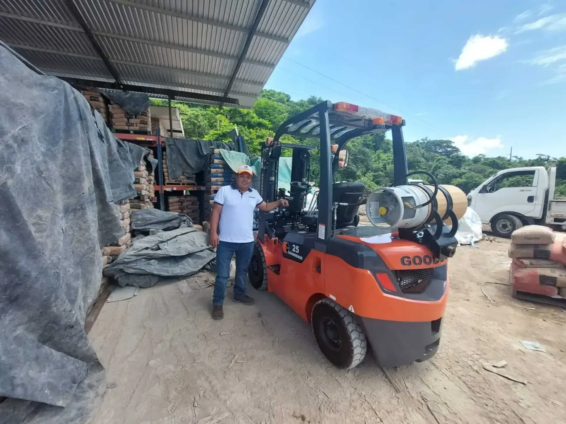 Un hombre parado al lado de un montacargas que dice bien