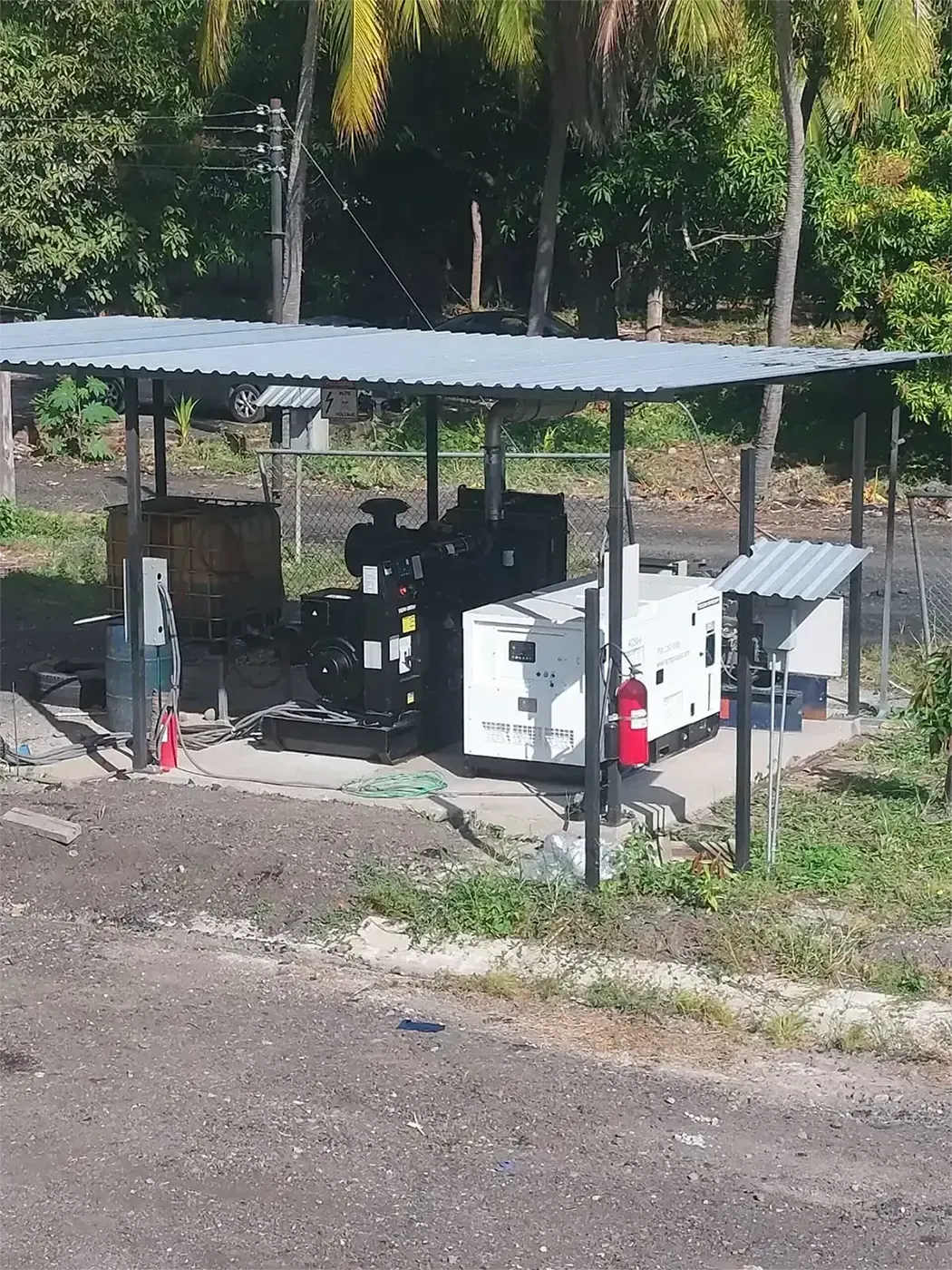Un camión blanco está estacionado bajo un techo metálico en un estacionamiento.