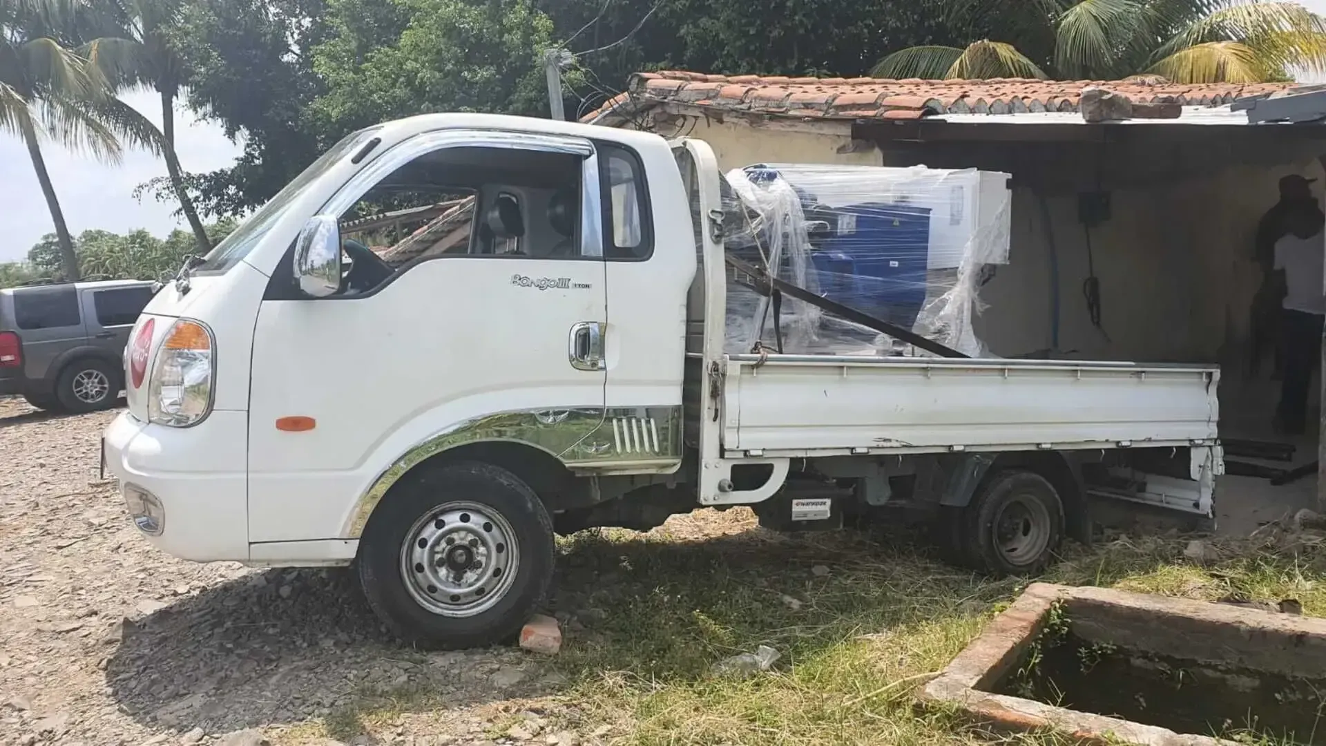 Un camión blanco está estacionado frente a un edificio.
