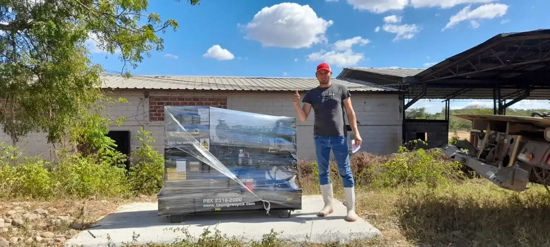 Un hombre está parado frente a una caja grande en un campo.