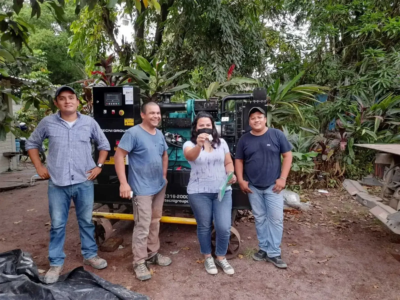 Un grupo de personas paradas una al lado de la otra frente a una máquina.