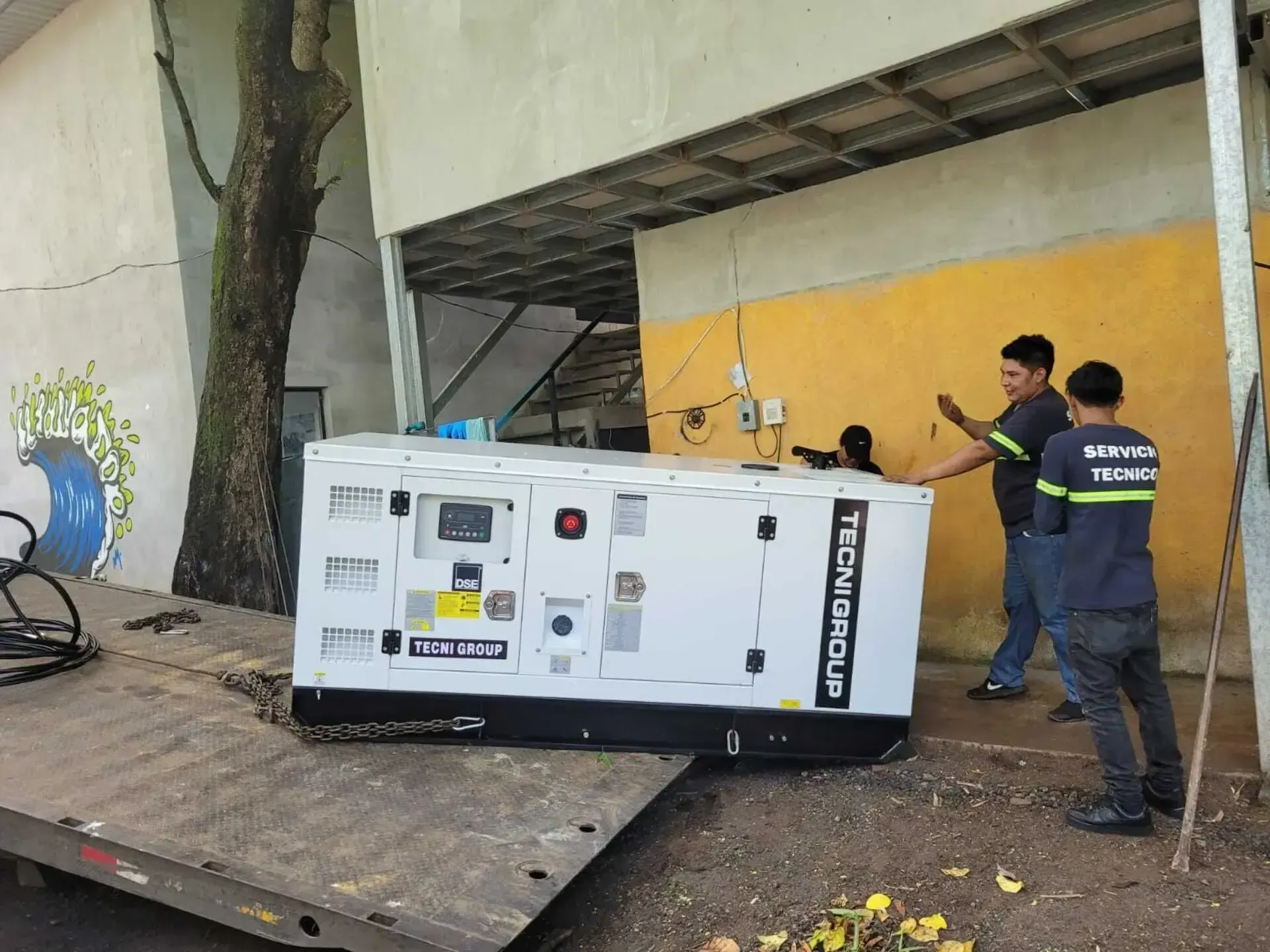 Un grupo de hombres está parado alrededor de un generador en un remolque.