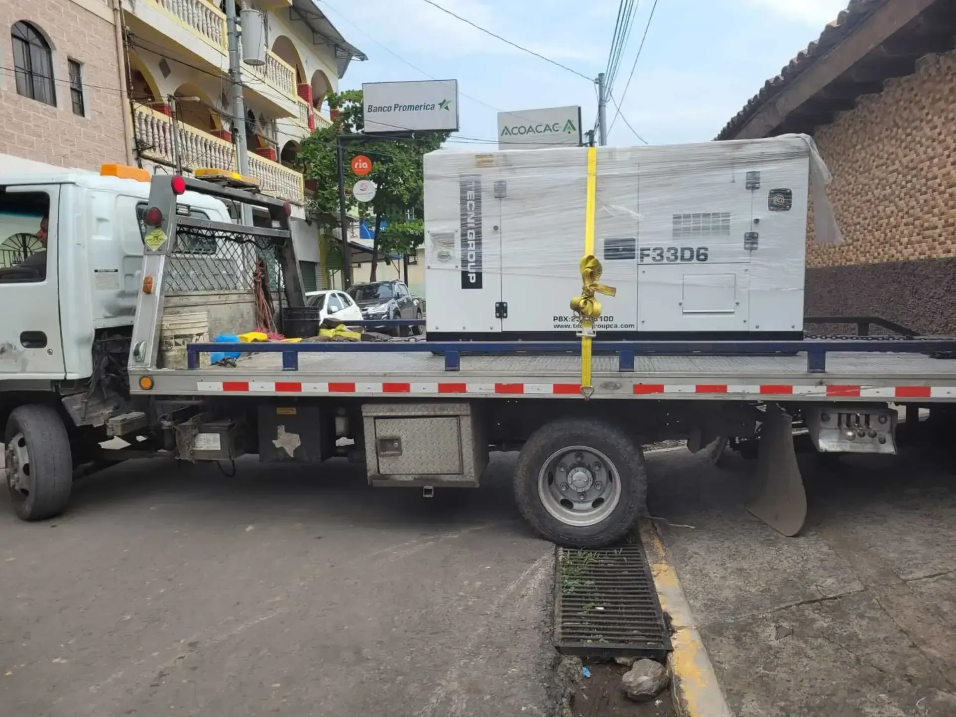 Una grúa lleva un generador en la parte trasera.