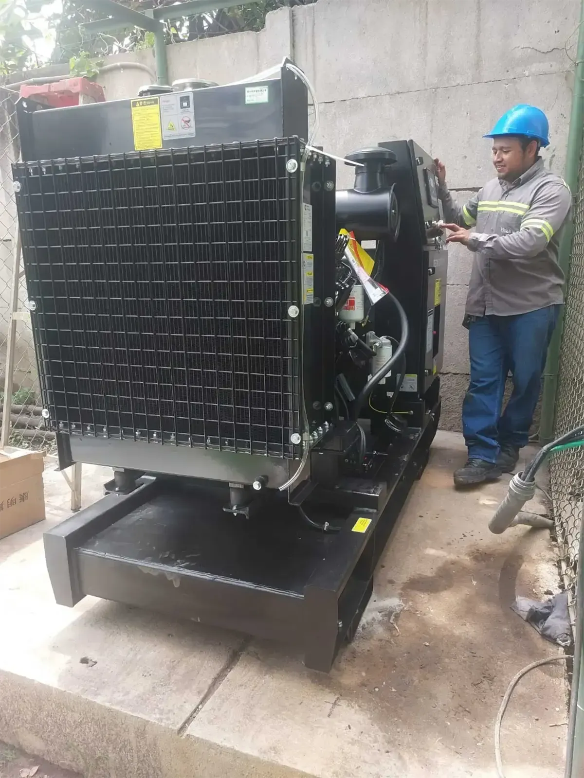 Un hombre con casco está trabajando en un generador.