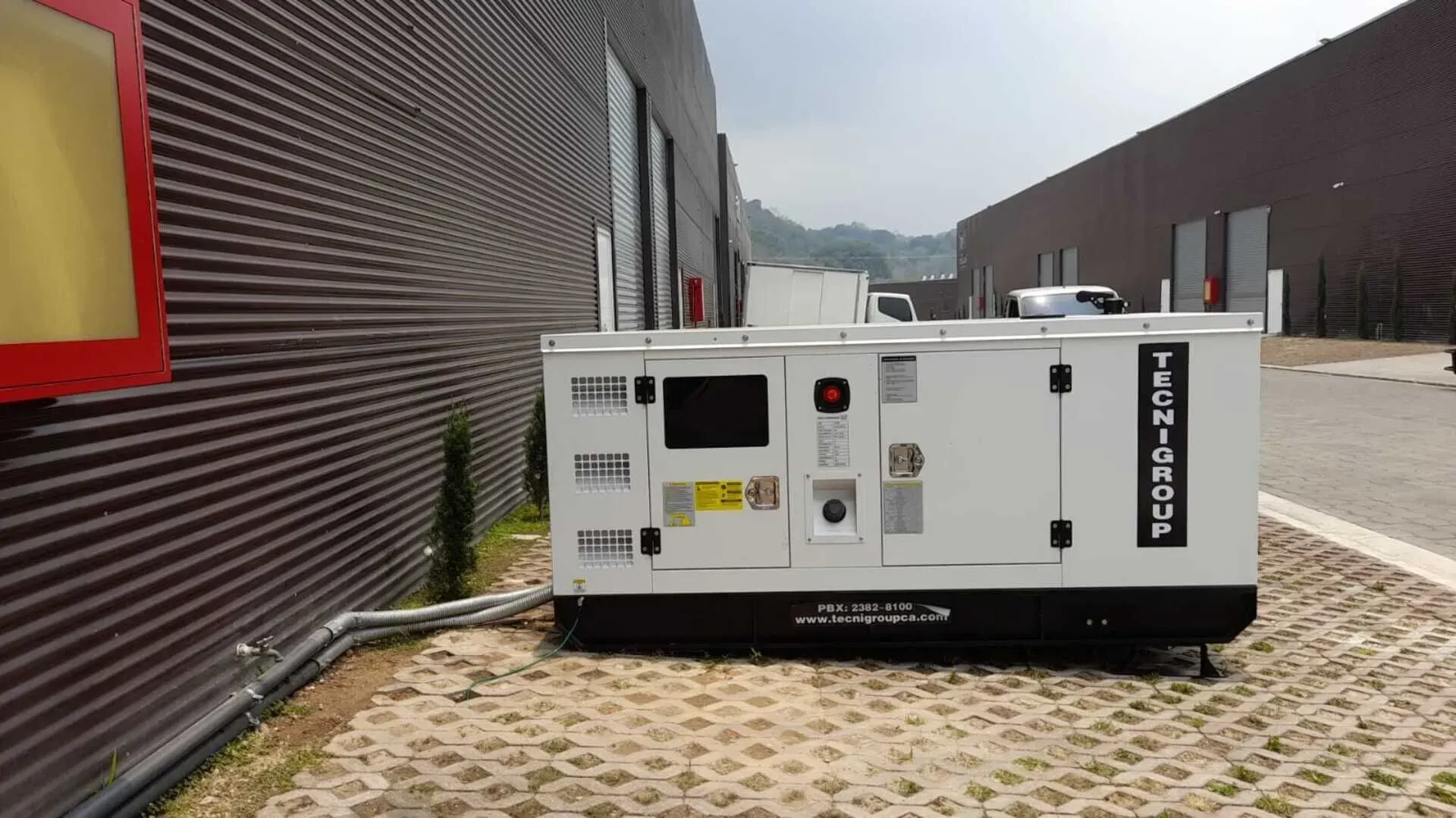 Un gran generador blanco está estacionado frente a un edificio.