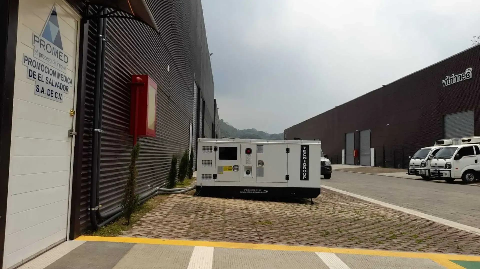 Una fila de camiones están estacionados frente a un edificio que dice proyecto