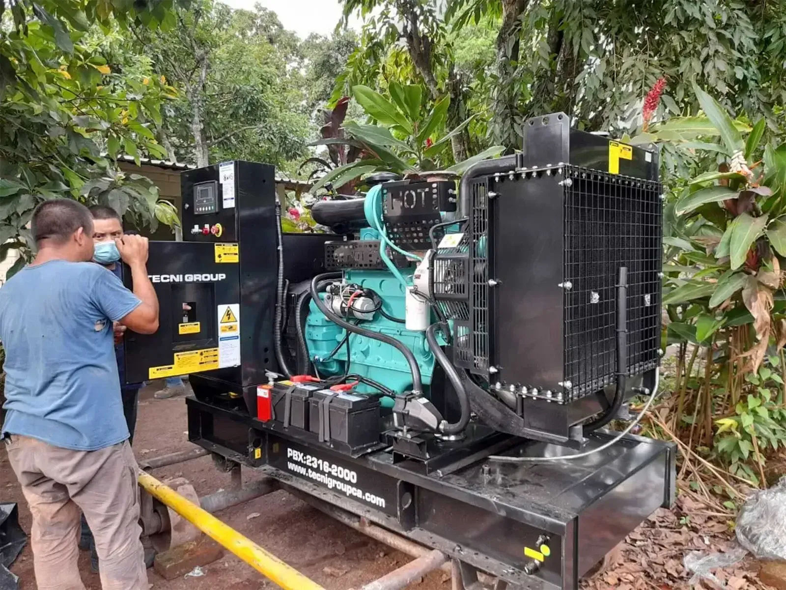 Un grupo de hombres está trabajando en un generador afuera.