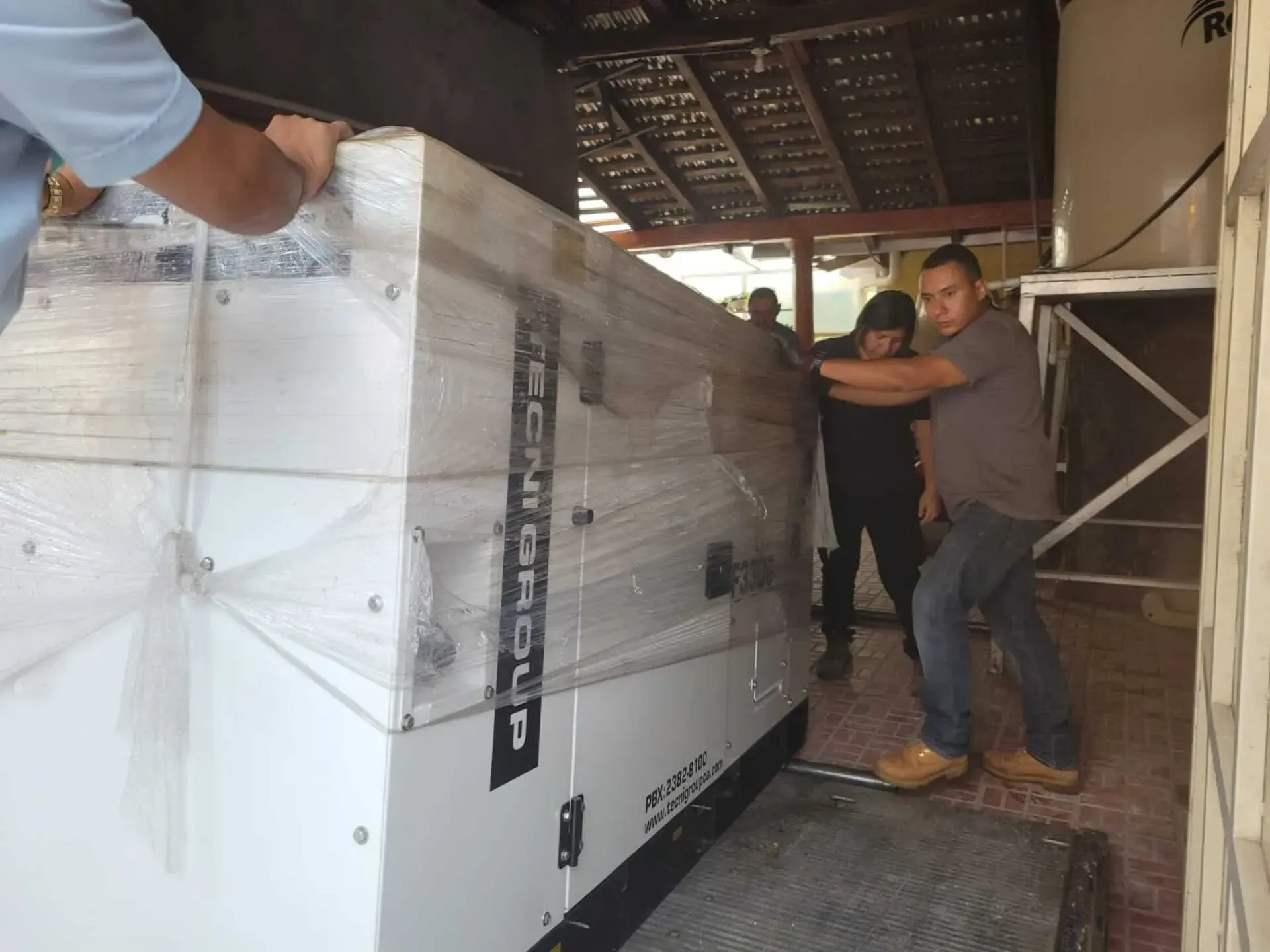 Un grupo de hombres cargando una caja que dice techni group