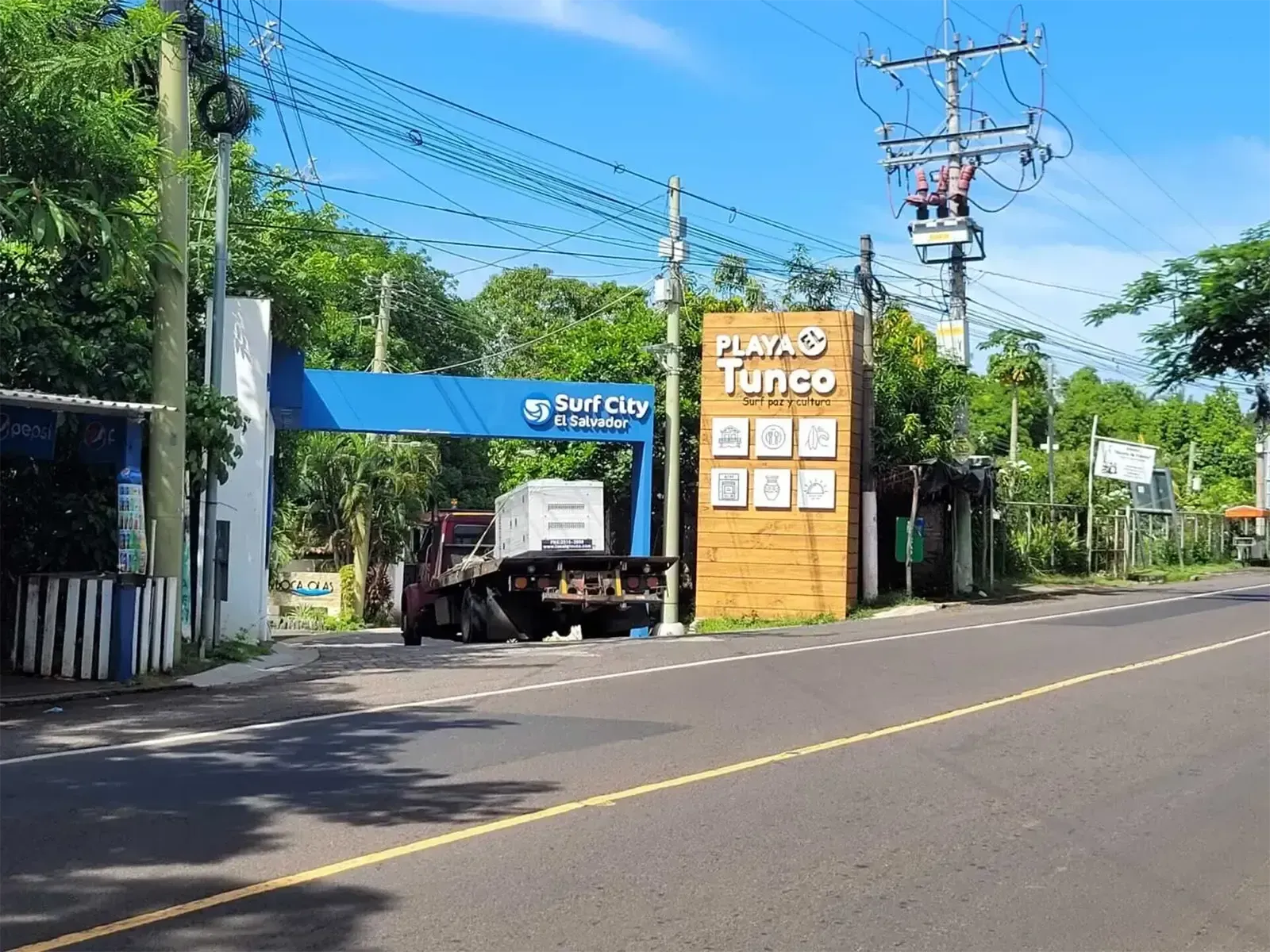 Una camioneta se encuentra estacionada al costado de la carretera frente a un cartel que dice playa tunco.