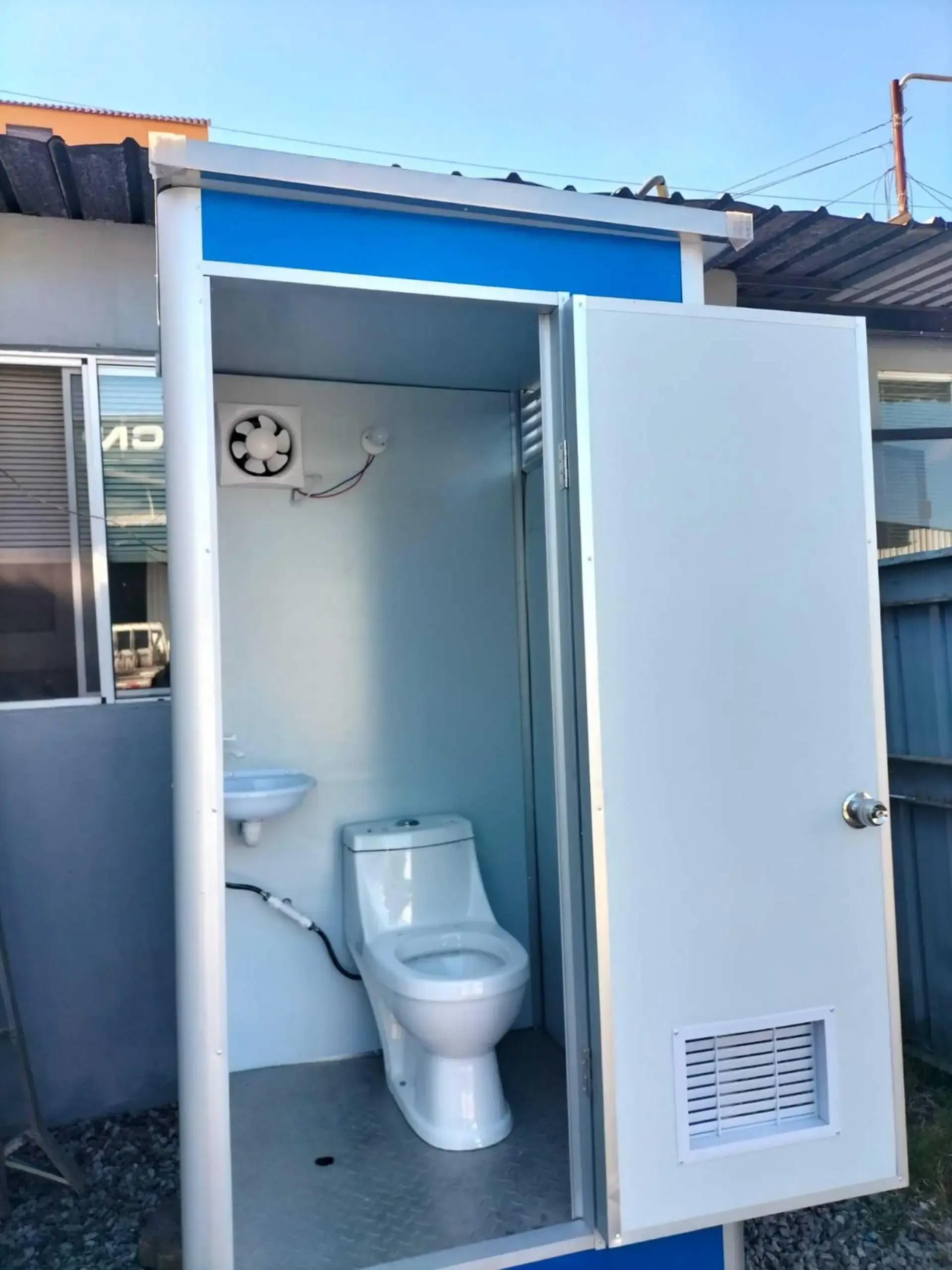 Un baño portátil con lavabo y ventilador.