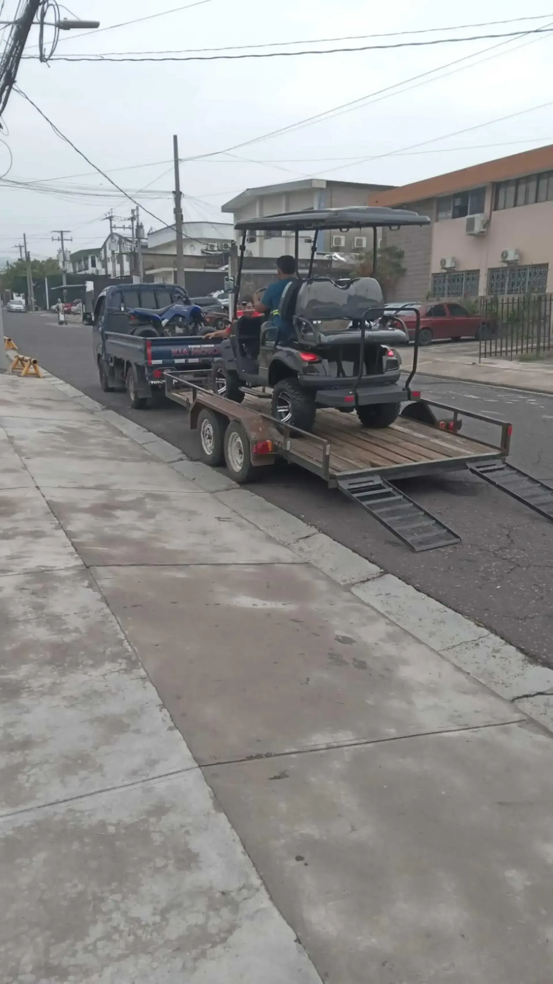 Un carrito de golf está siendo remolcado por una calle en un remolque.