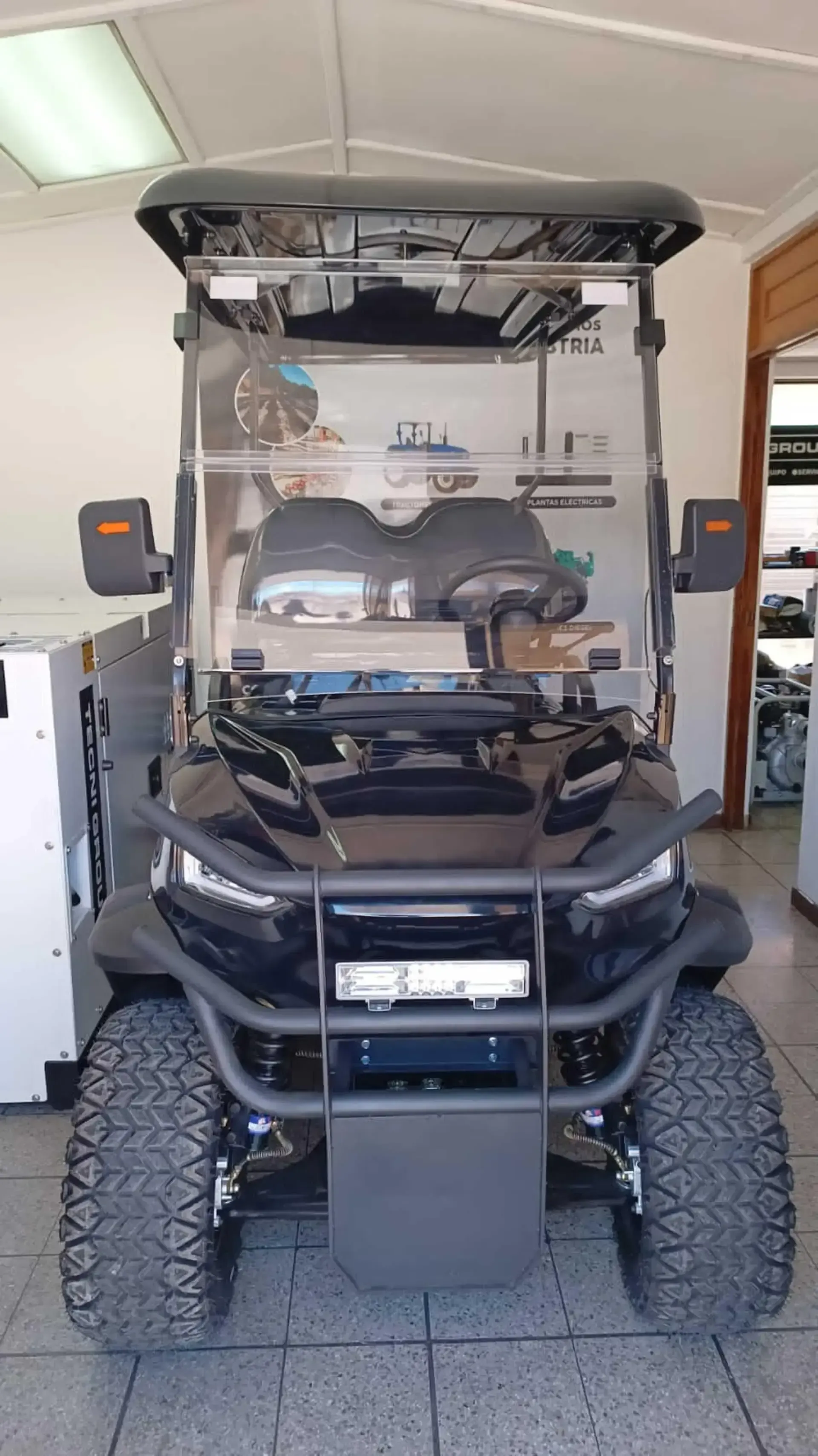 Un carrito de golf negro está estacionado en un garaje.