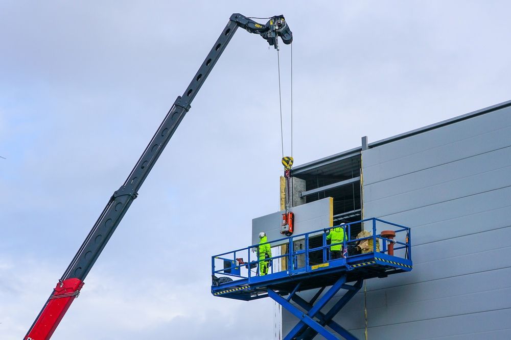 A Crane Lifting A Wall Panel For Installation On A Building — East Coast Cranes in Ormeau, QLD