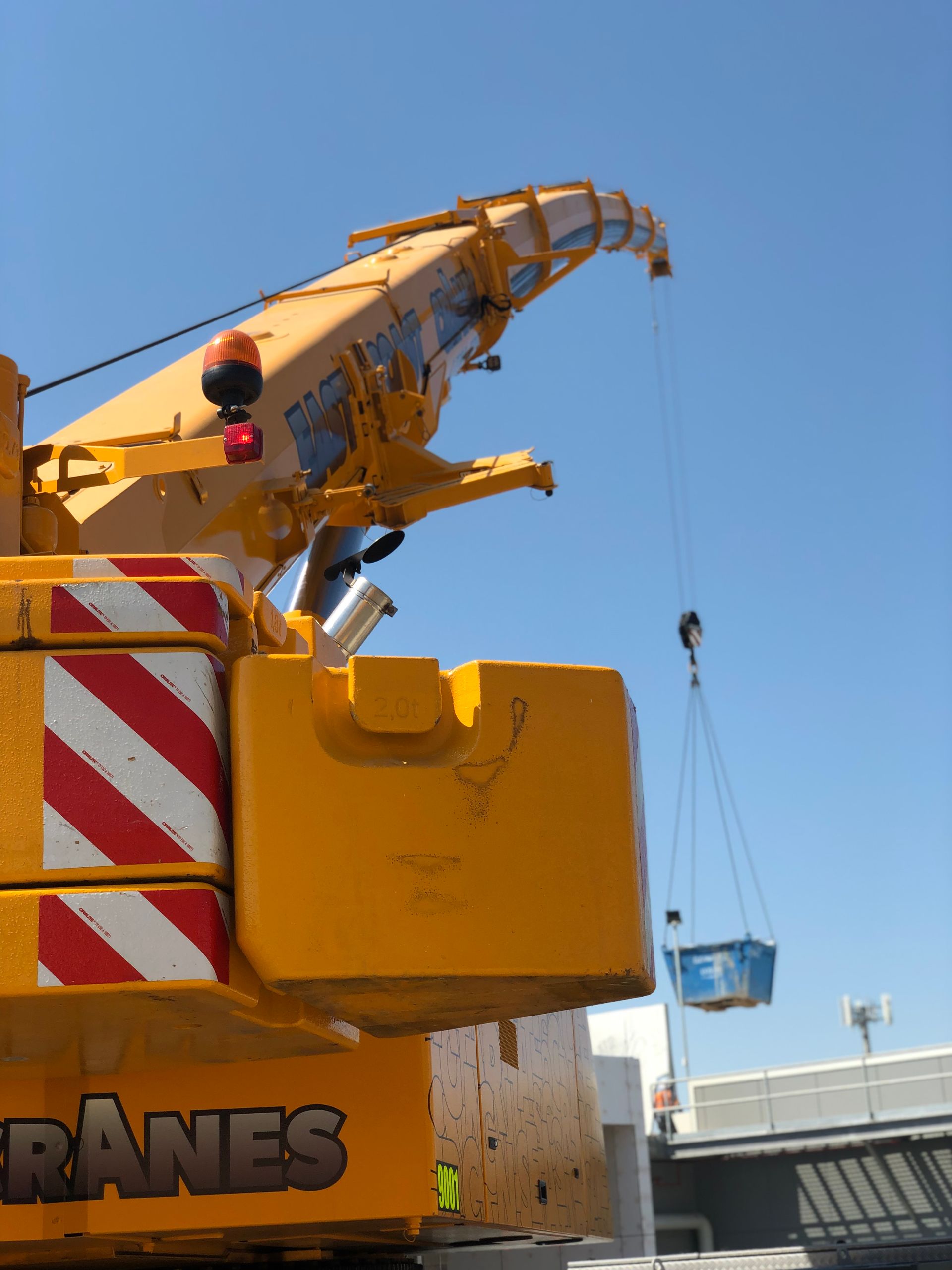 Yellow Crane Lifting A Concrete Beam At A Construction Site — East Coast Cranes in Ormeau, QLD
