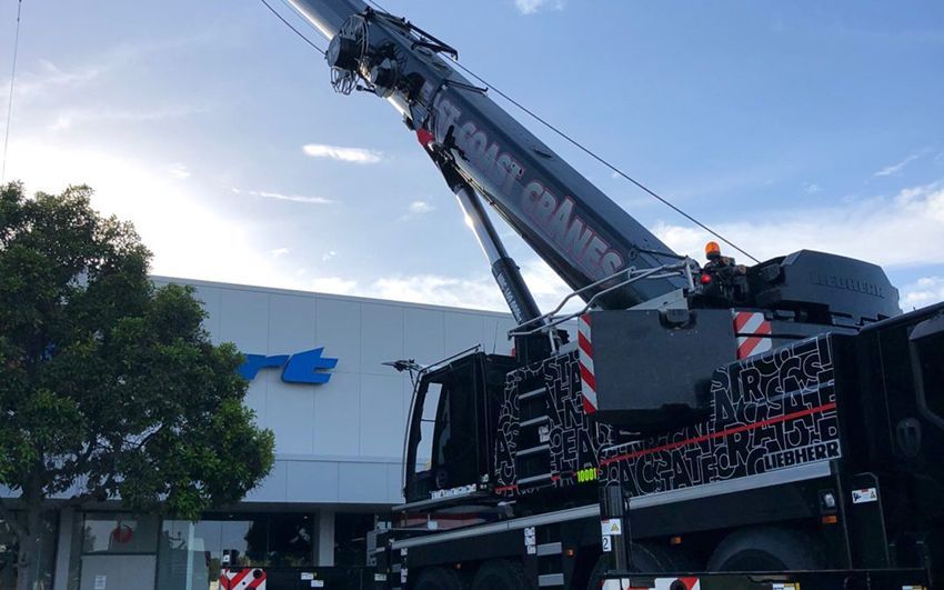 A Large Crane Is Parked in Front of A Building — East Coast Cranes in Ormeau, QLD