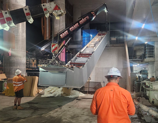 Workers Using a Crane to Lift a Large Metal Structure Inside a Construction Site — East Coast Cranes in Ormeau, QLD