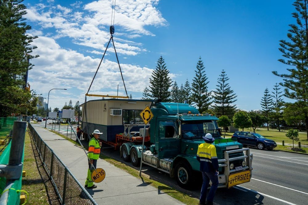A Truck Is Being Loaded with A Trailer on The Side of The Road — East Coast Cranes in Ormeau, QLD