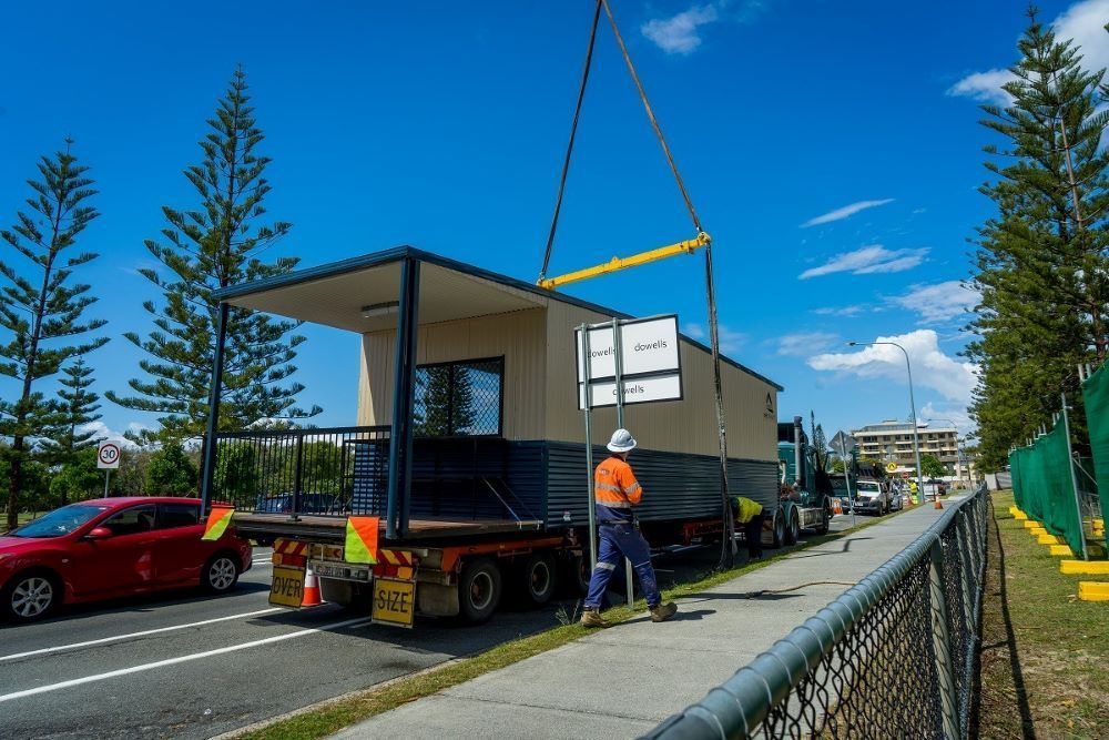 A Man Is Lifting a Building on Top of A Truck — East Coast Cranes in Ormeau, QLD