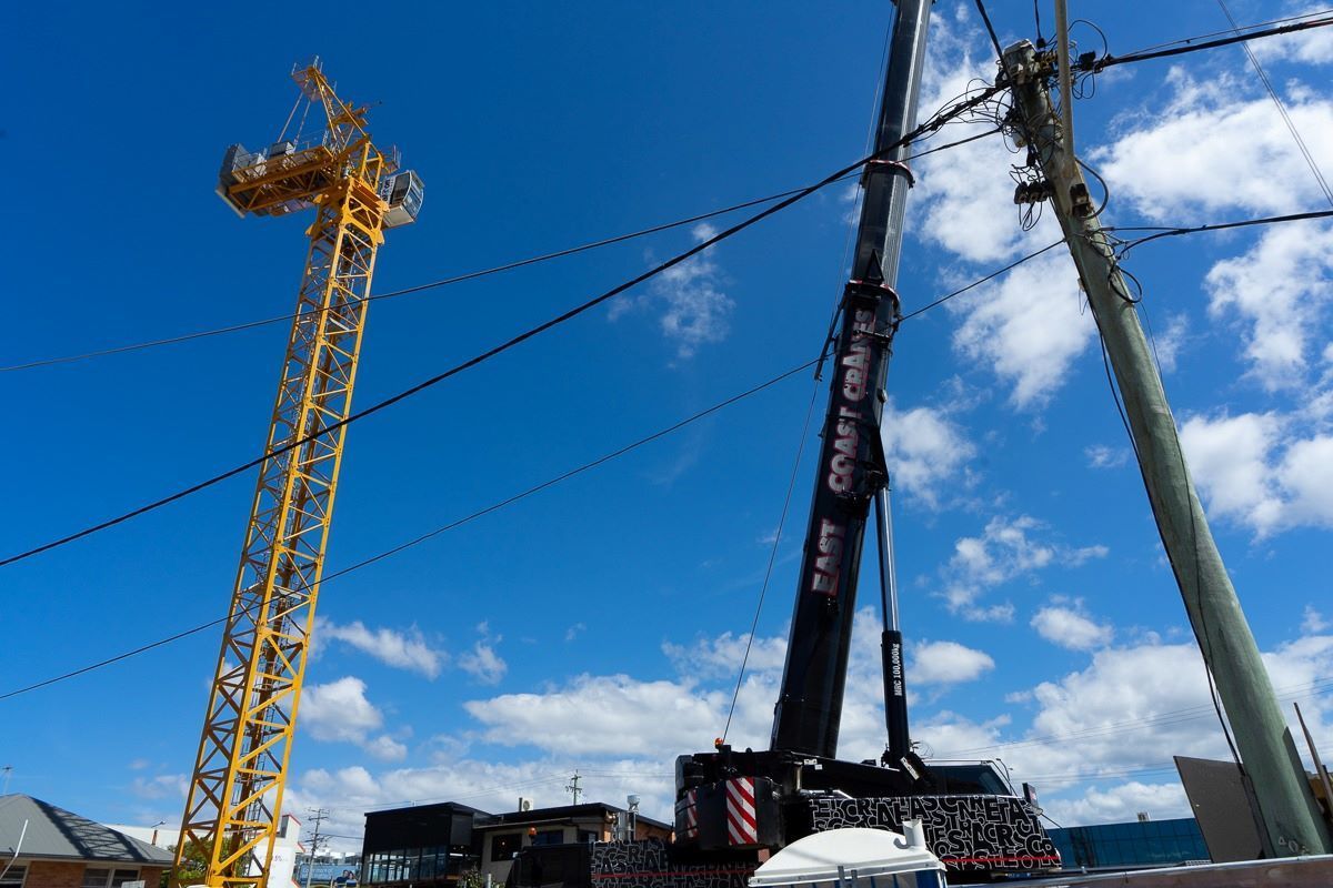 A Large Crane Is Sitting Next to A Yellow Crane on A Construction Site — East Coast Cranes in Ormeau, QLD