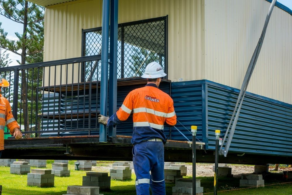A Group of Construction Workers Are Working on A House — East Coast Cranes in Ormeau, QLD