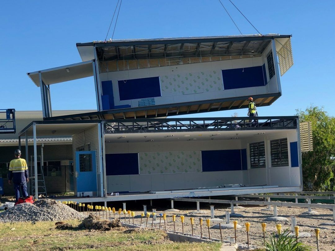 A Man Is Standing in Front of A Building that Is Being Built — East Coast Cranes in Ormeau, QLD