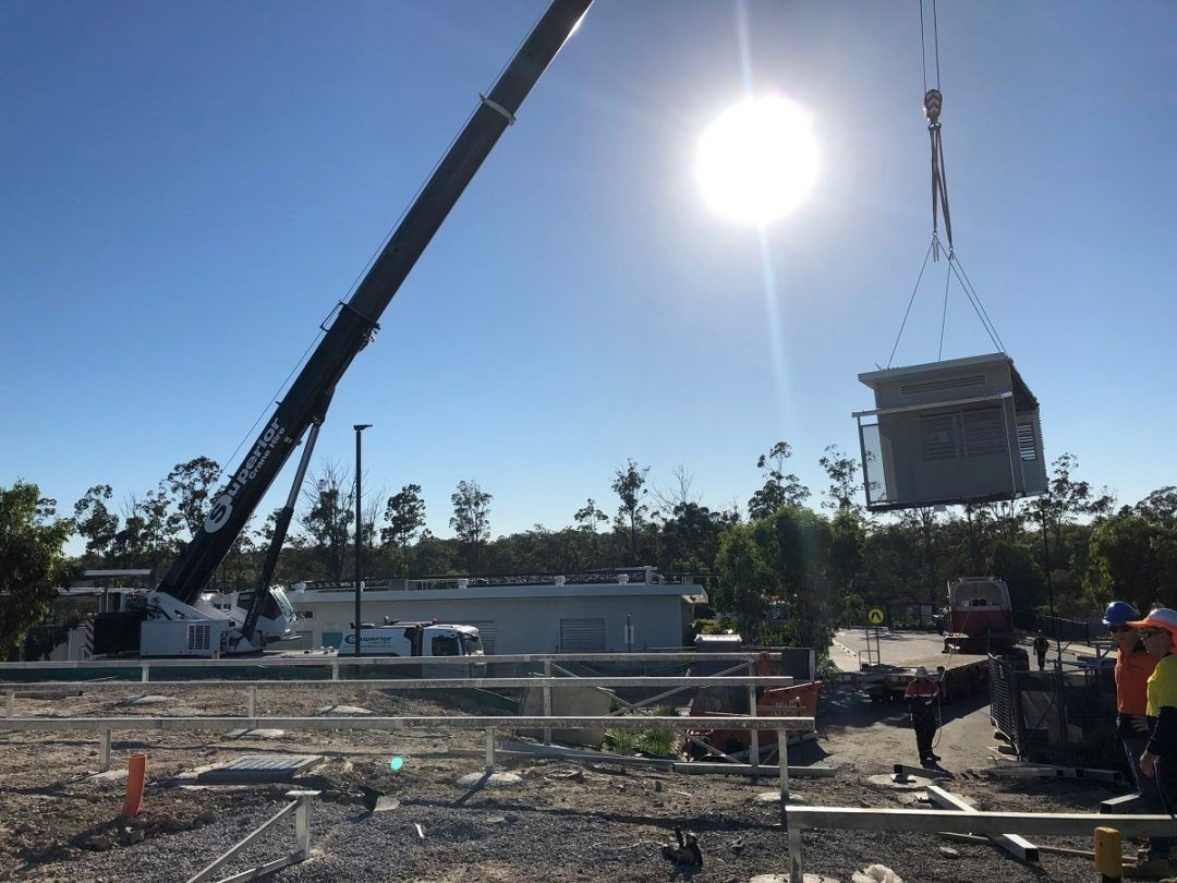 A Crane Is Lifting a Building in The Air — East Coast Cranes in Ormeau, QLD
