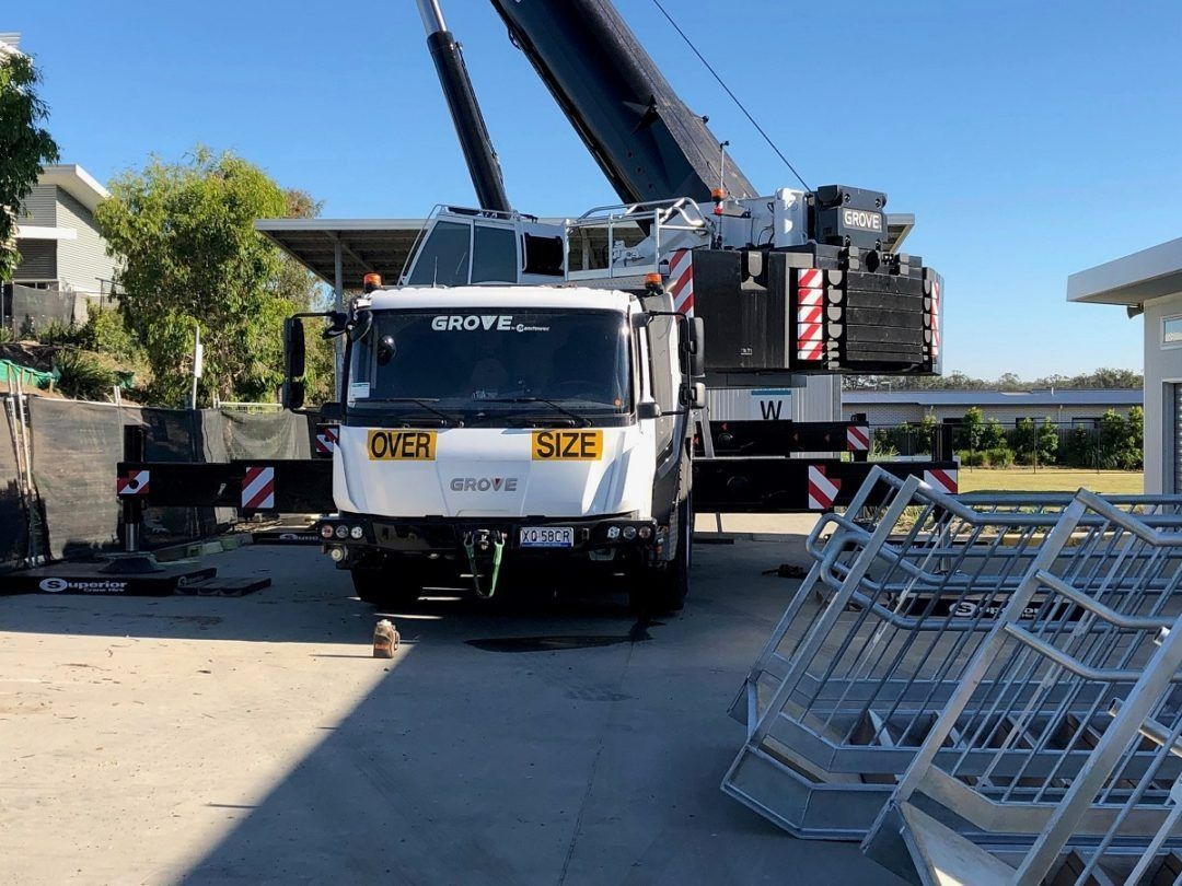 A Large Crane Is Sitting on Top of A Truck in A Parking Lot — East Coast Cranes in Ormeau, QLD