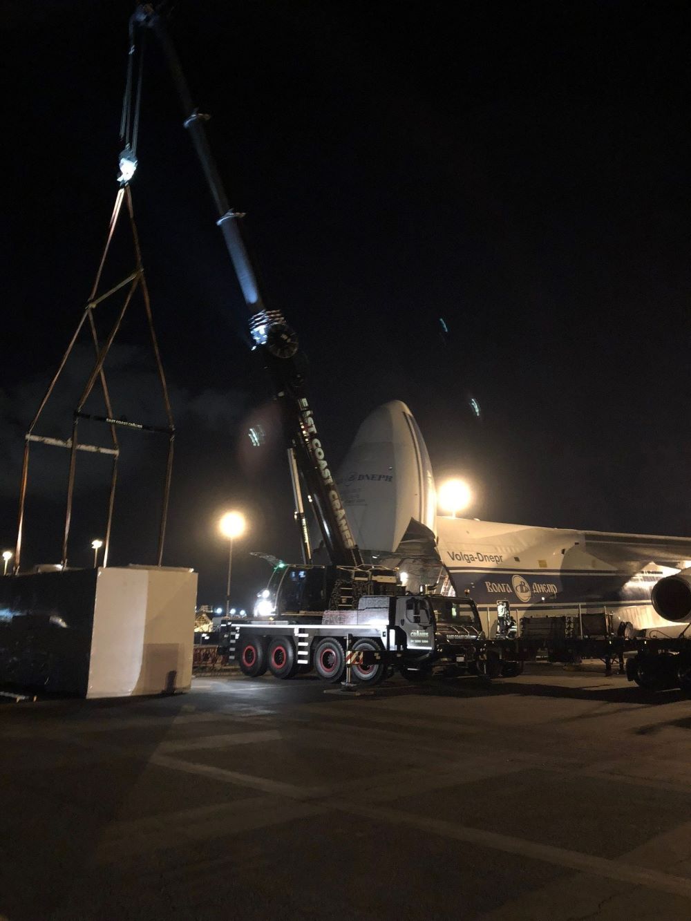 A Large Airplane Is Being Lifted by A Crane at Night — East Coast Cranes in Ormeau, QLD