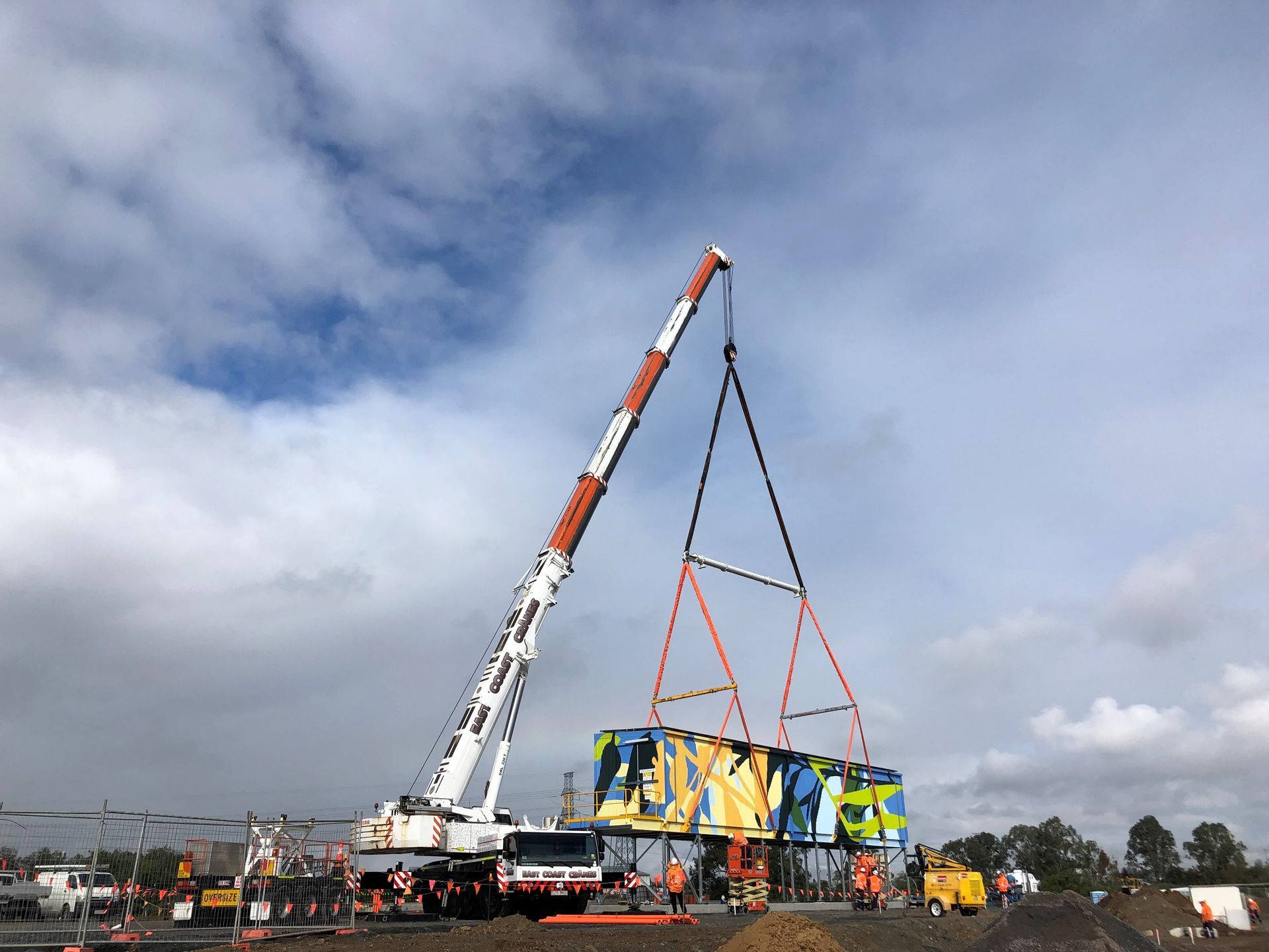 A Large Crane Is Lifting a Container in The Air — East Coast Cranes in Ormeau, QLD