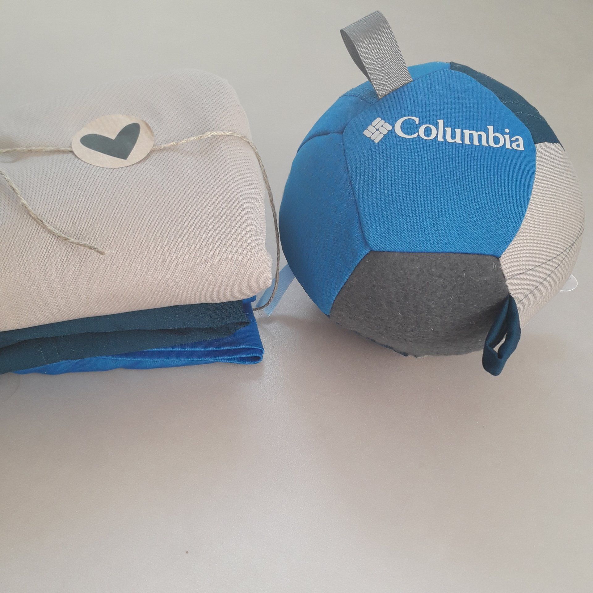 Een blauwe columbiabal ligt naast een stapel handdoeken