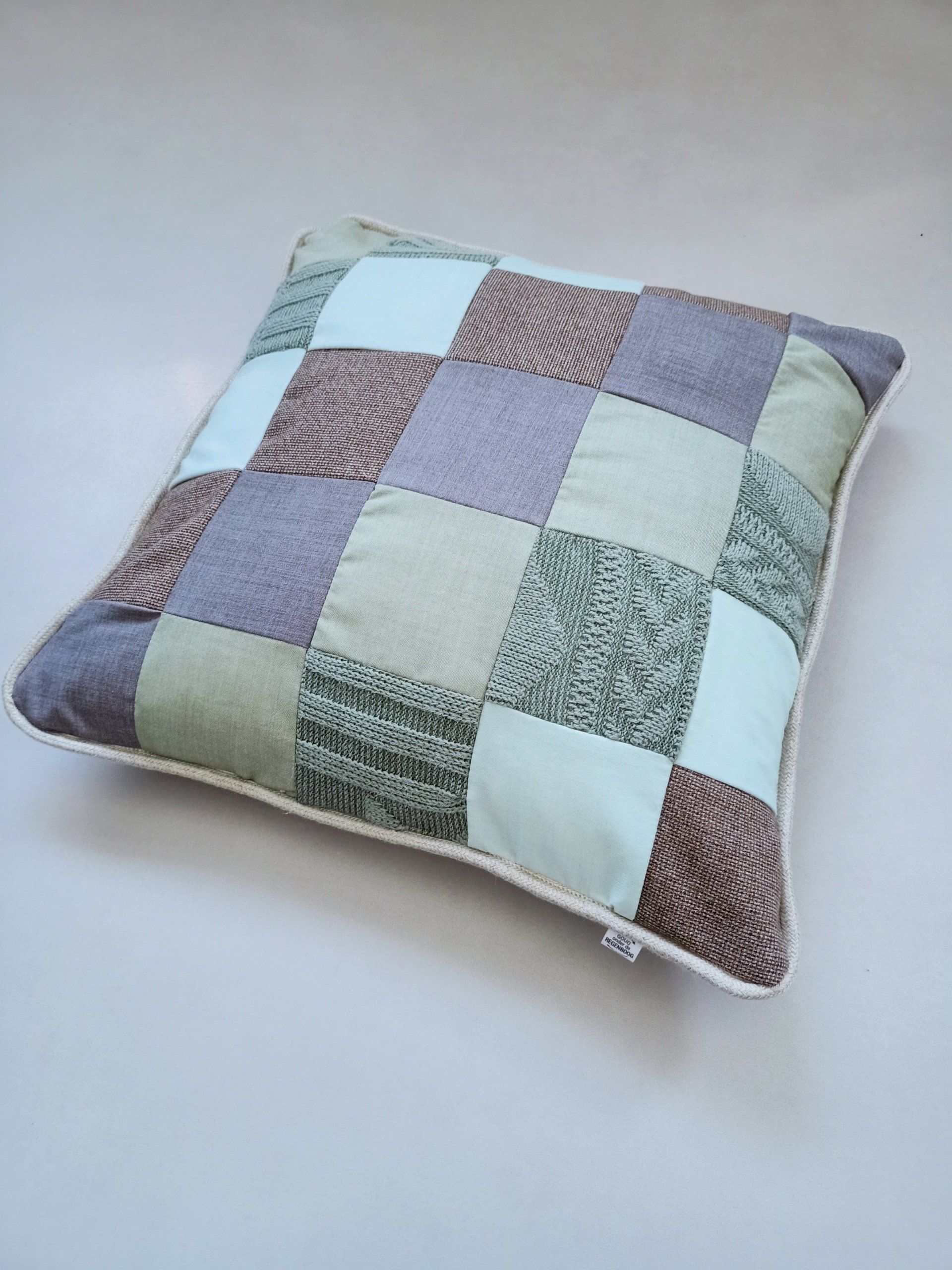 Op tafel ligt een kussen met een patchworkpatroon.