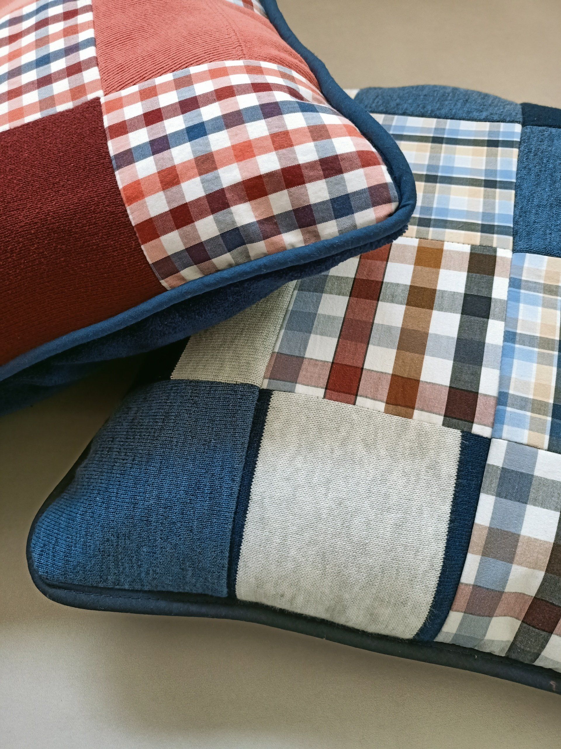 Twee geruite troostkussens liggen op elkaar op een tafel