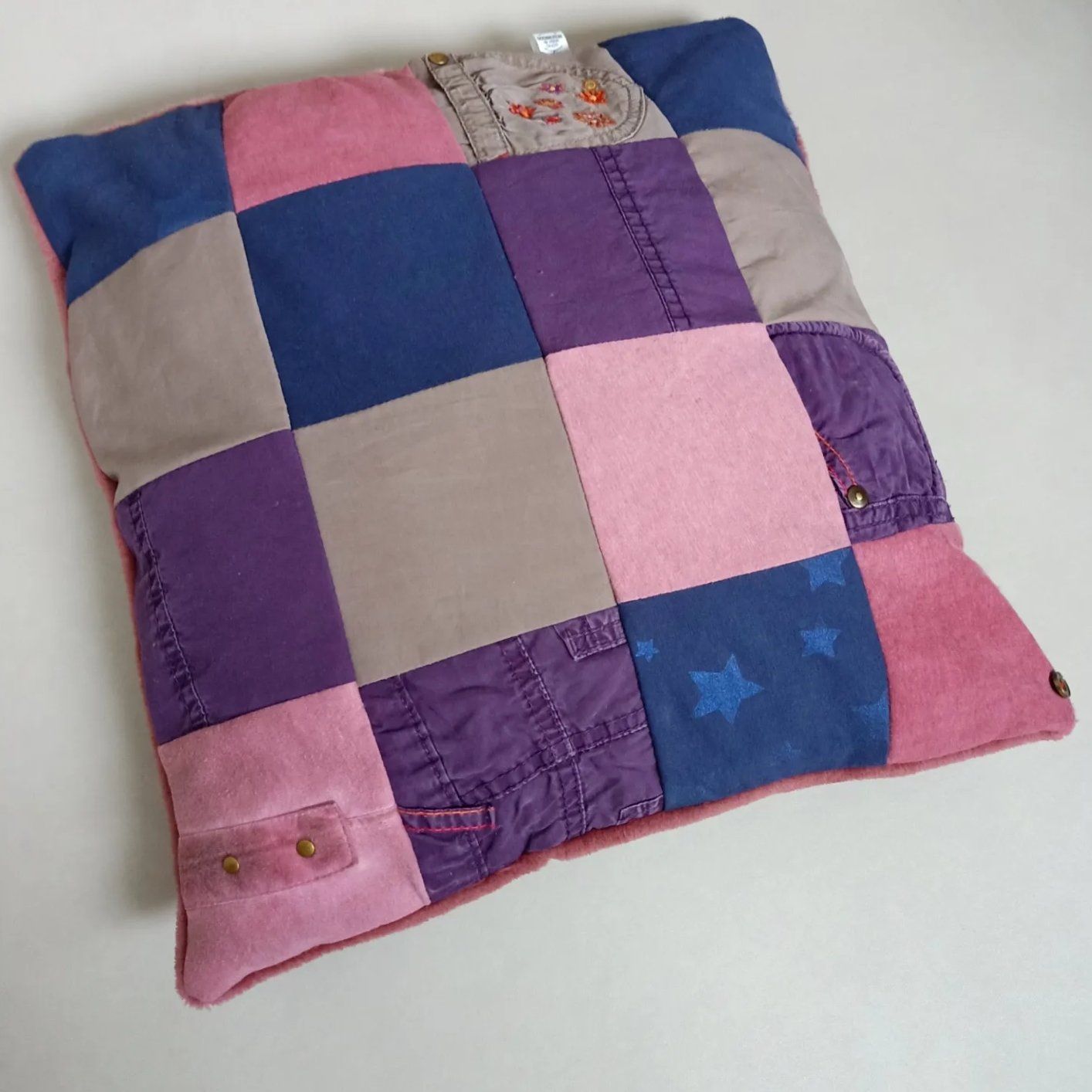 Een roze paars en blauw kussen met sterren erop