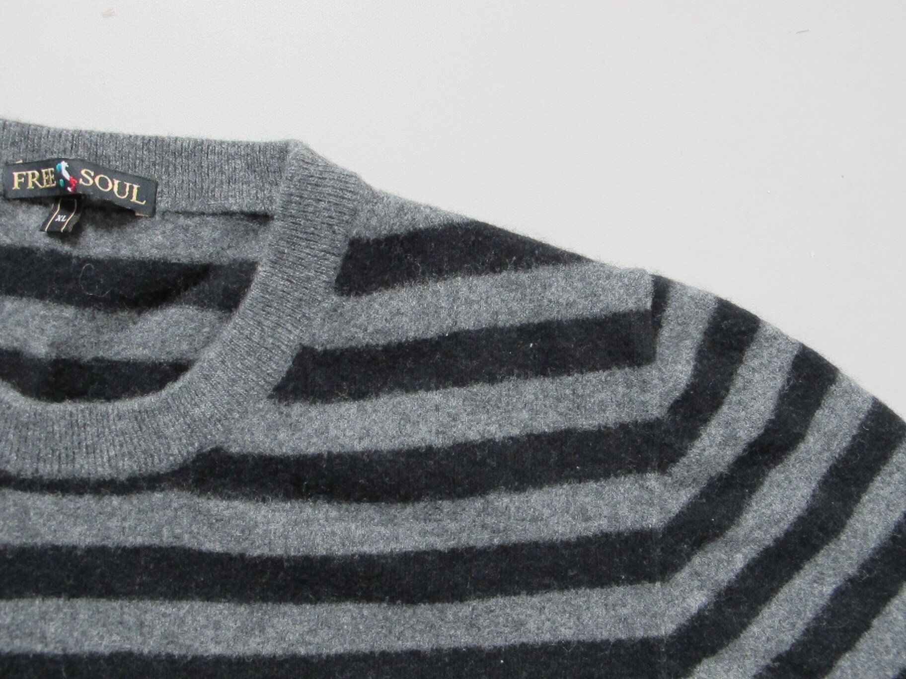 Een close-up van een grijs en zwart gestreepte trui