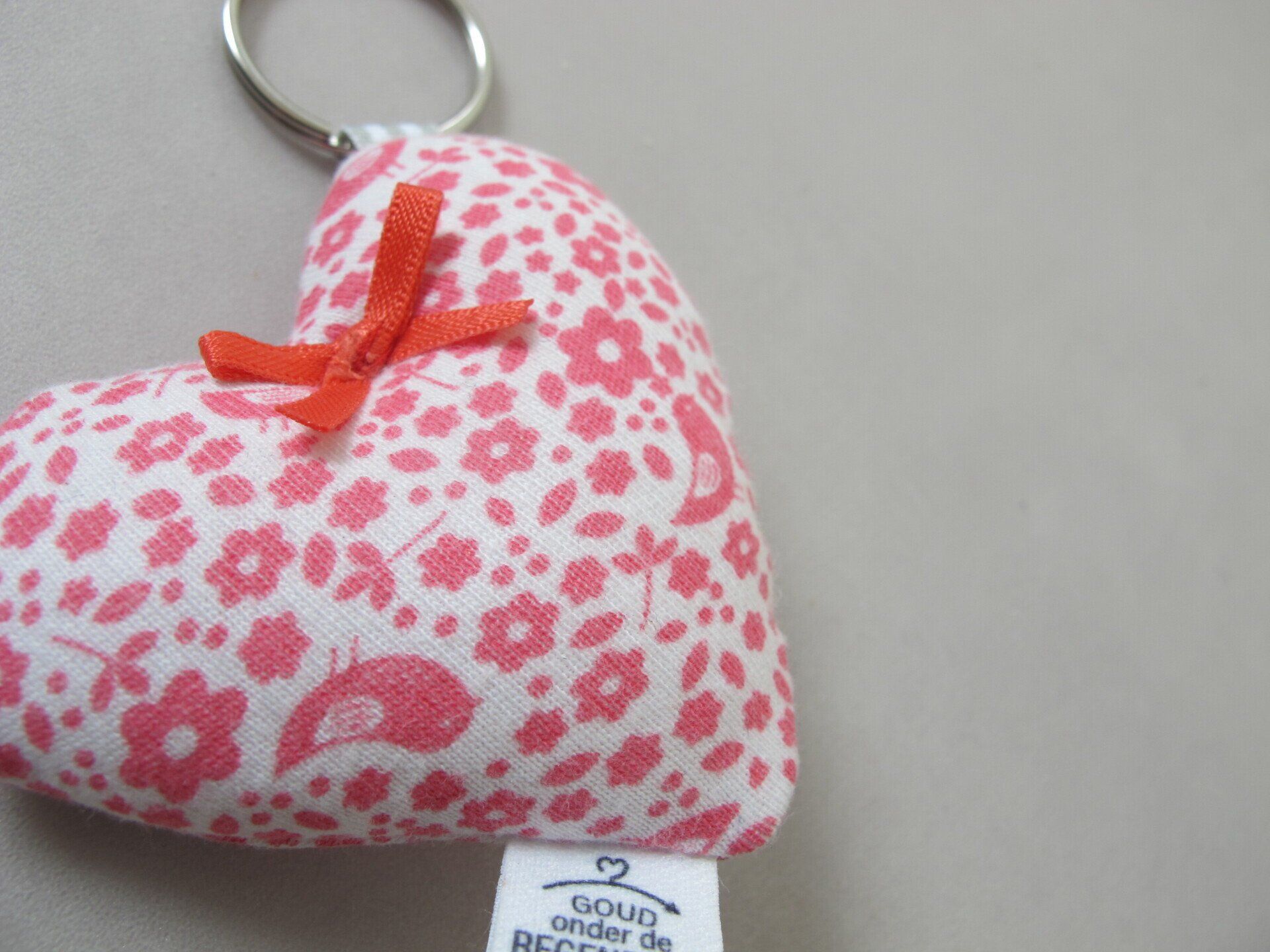 Een sleutelhanger in de vorm van een hart met een label waarop staat goud show de