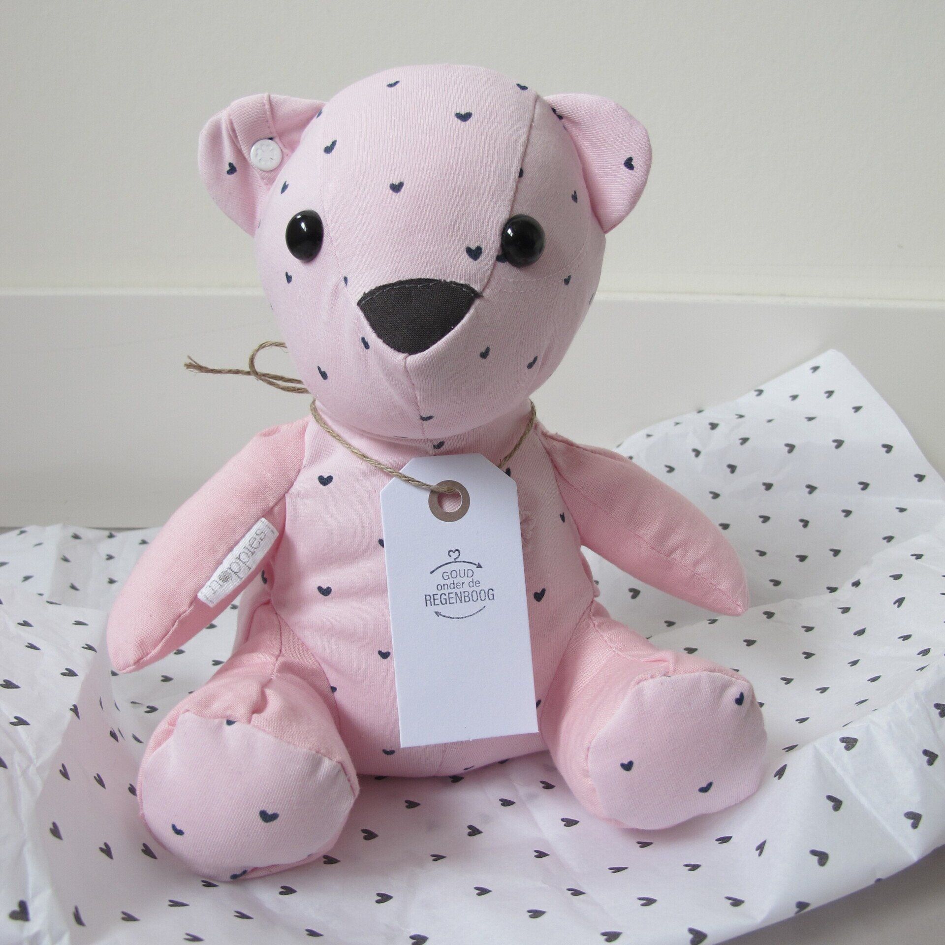 Een roze herinneringsbeer met een label eraan