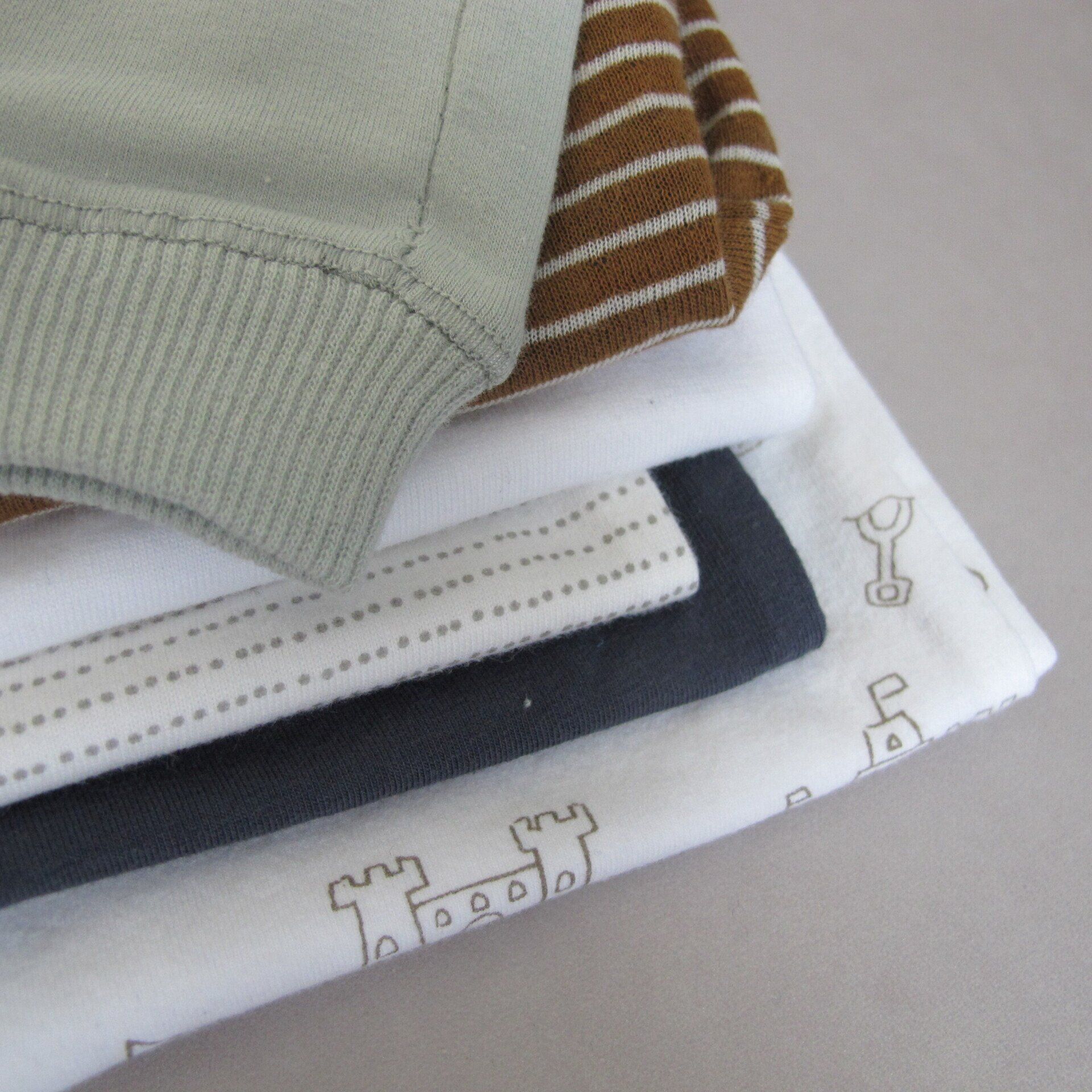 Een stapel babykleertjes met een kasteel erop