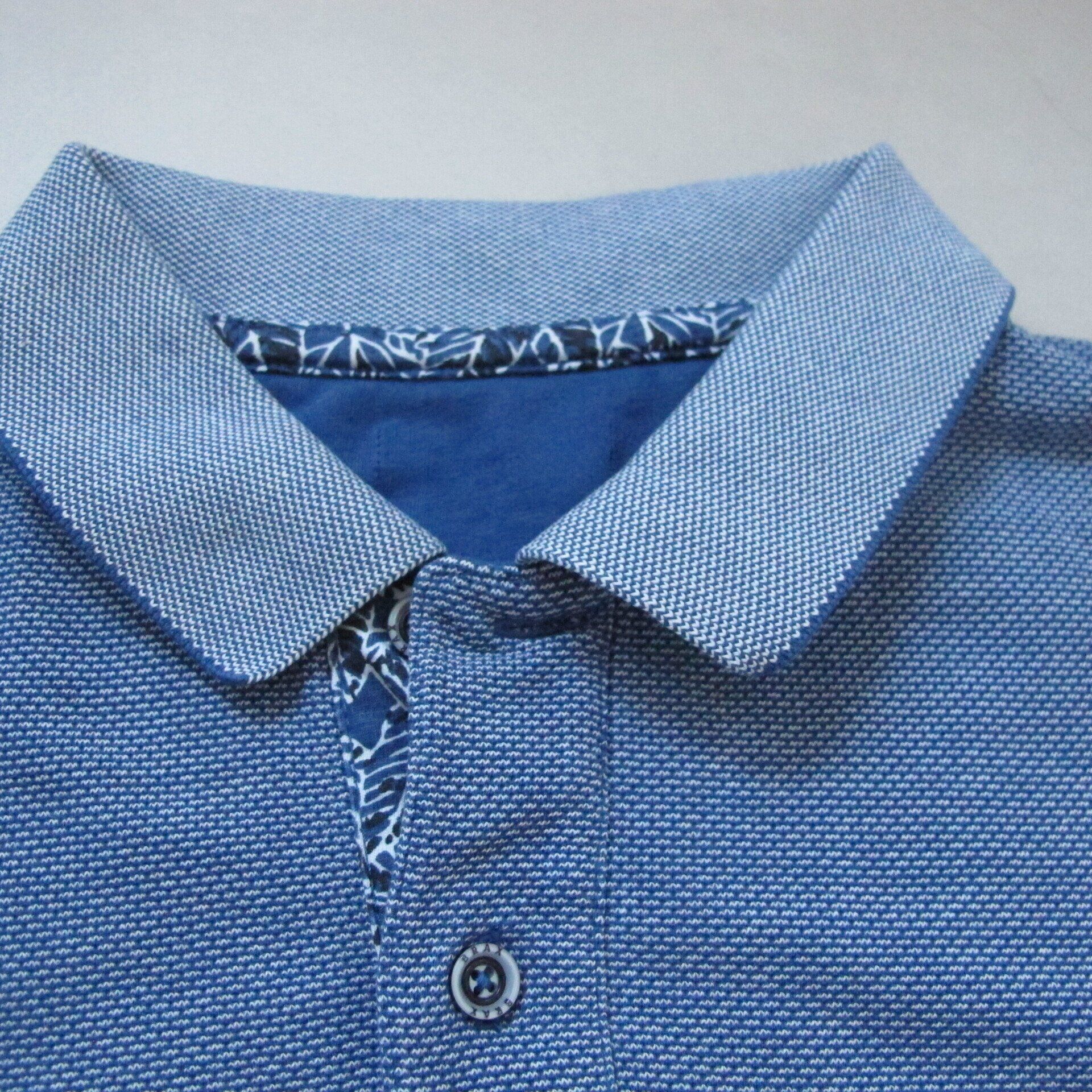 Een close-up van een blauw poloshirt met een blauwe kraag