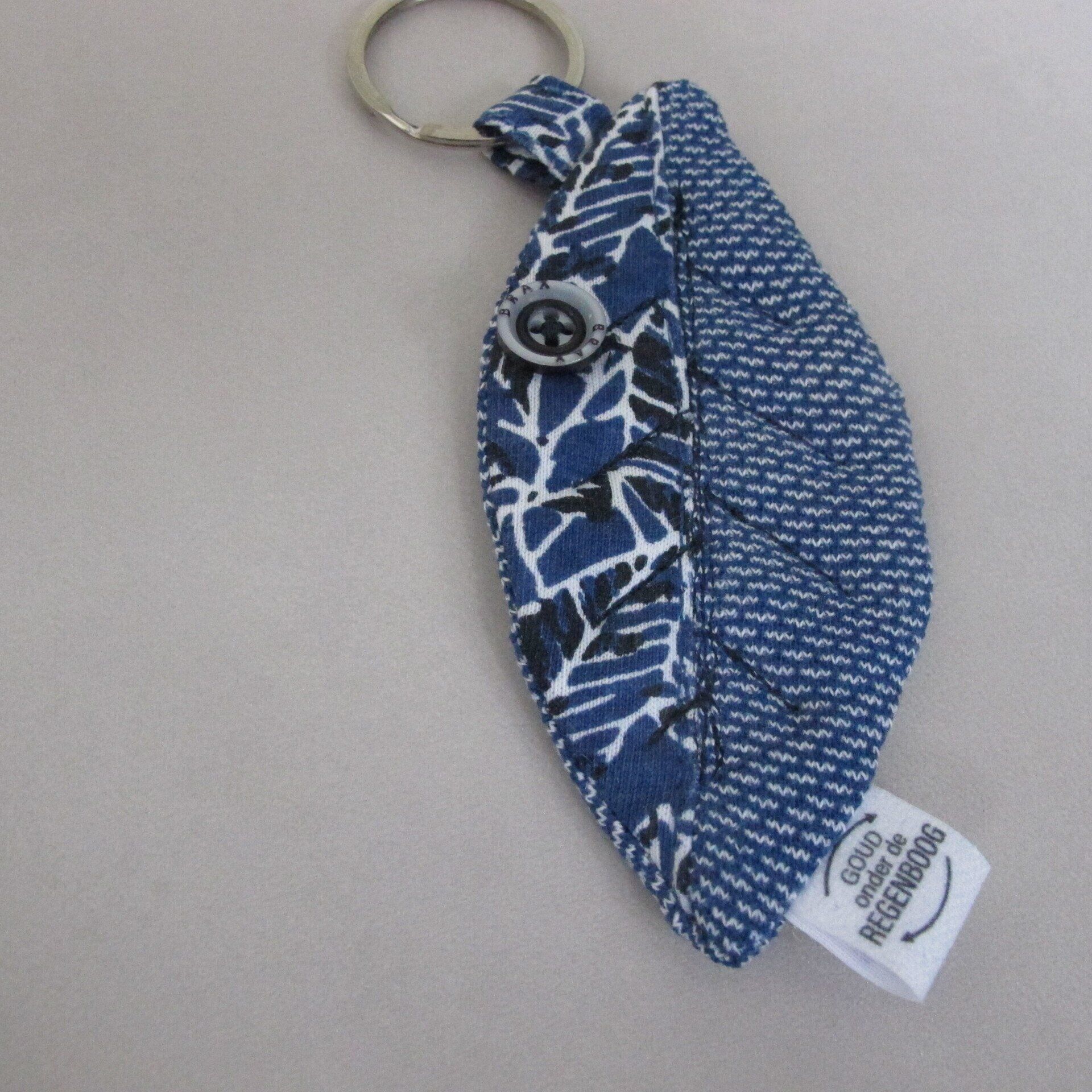 Een blauw-witte sleutelhanger met een label met de tekst 'good vibrations' erop