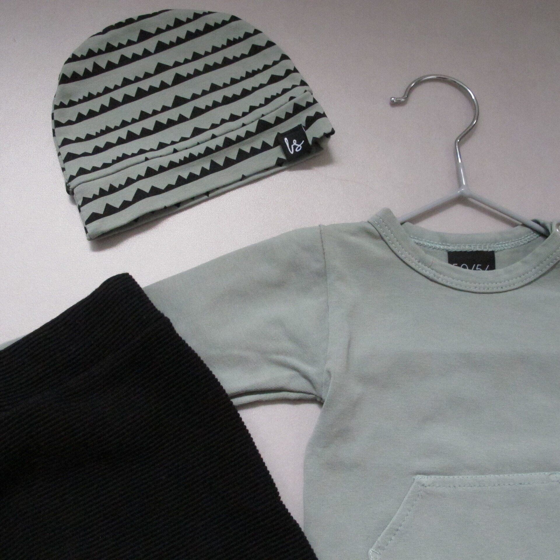 Een babyoutfit bestaat uit een hoed en een shirt