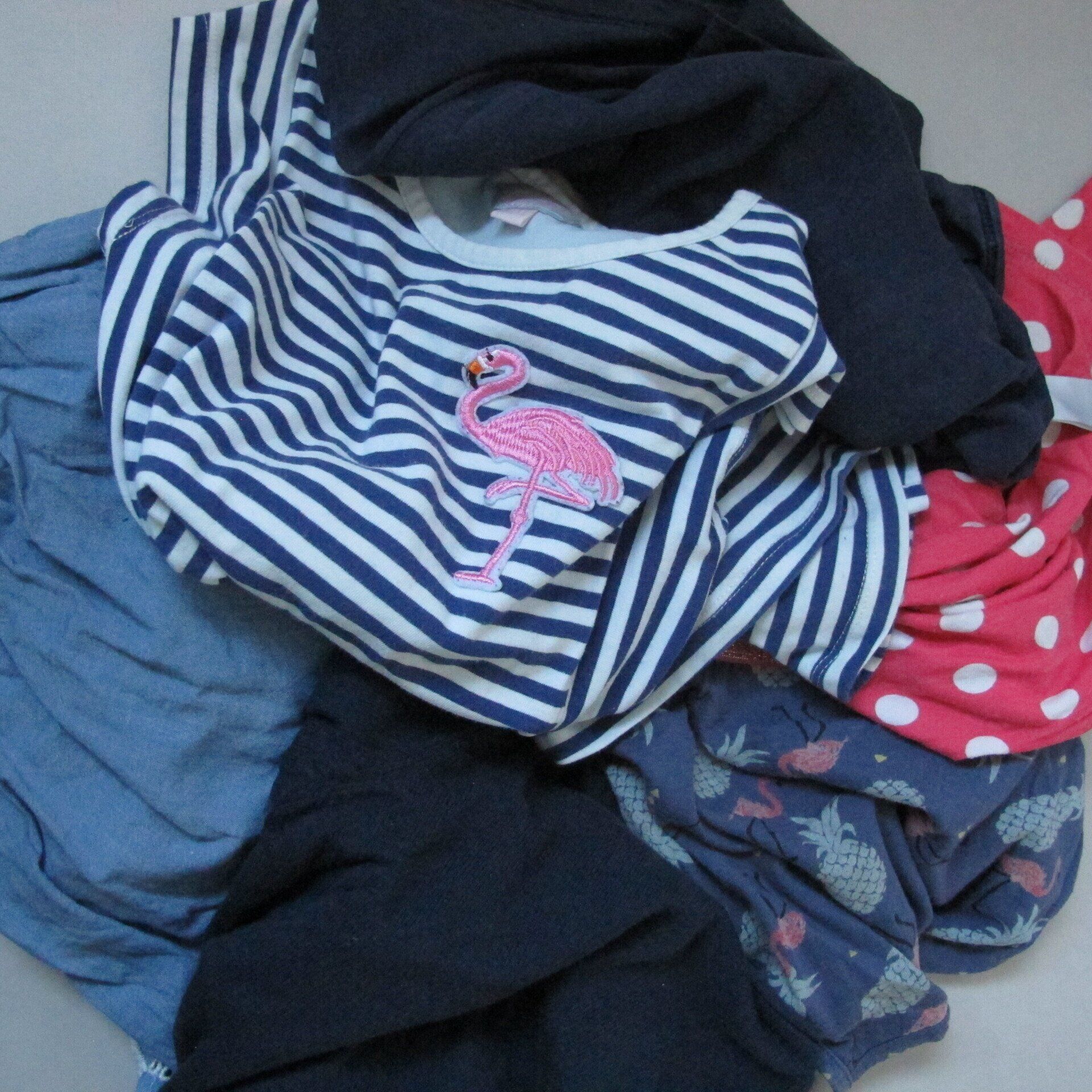 Een stapel kleding met een flamingo op een gestreept shirt