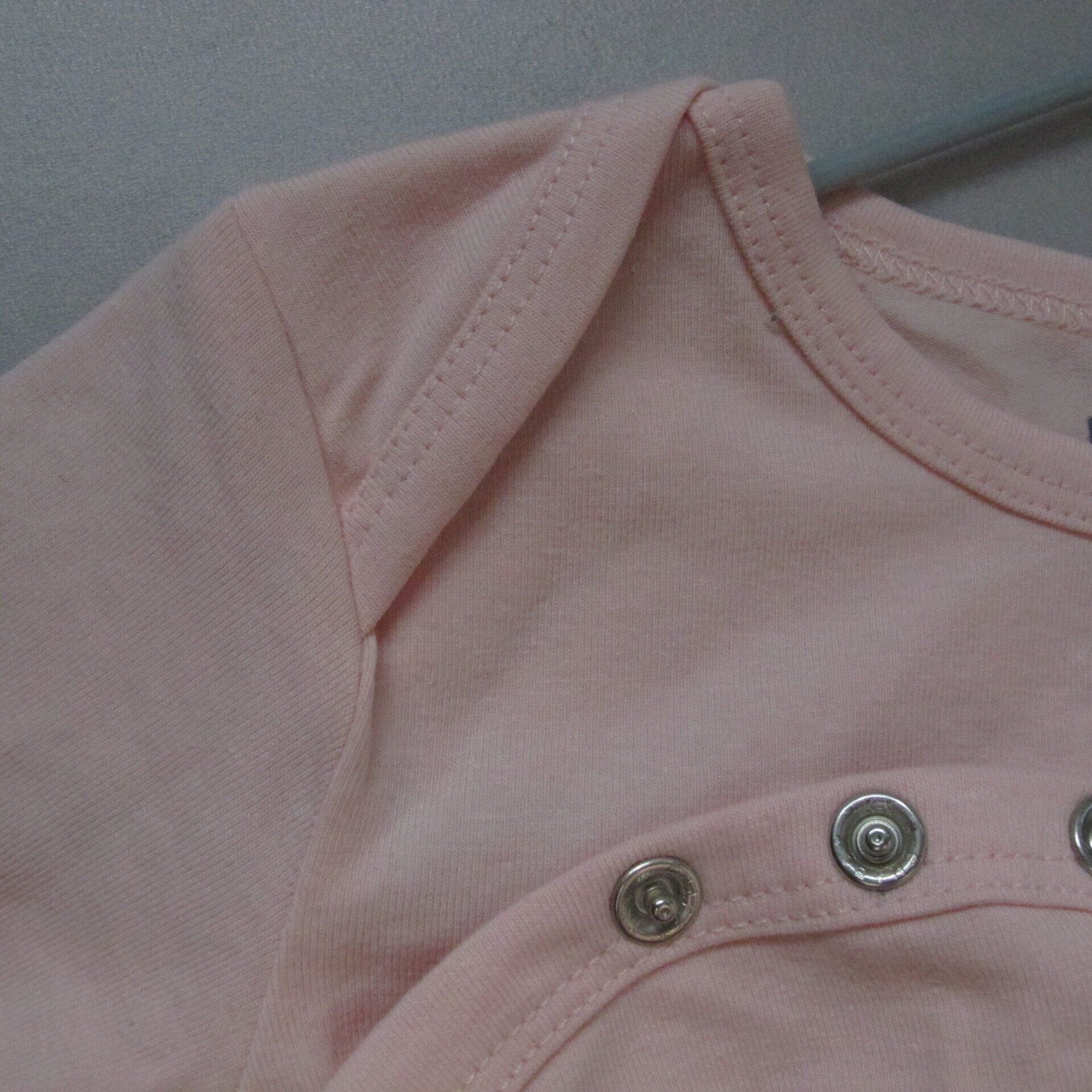 Een close-up van een roze shirt met knopen erop